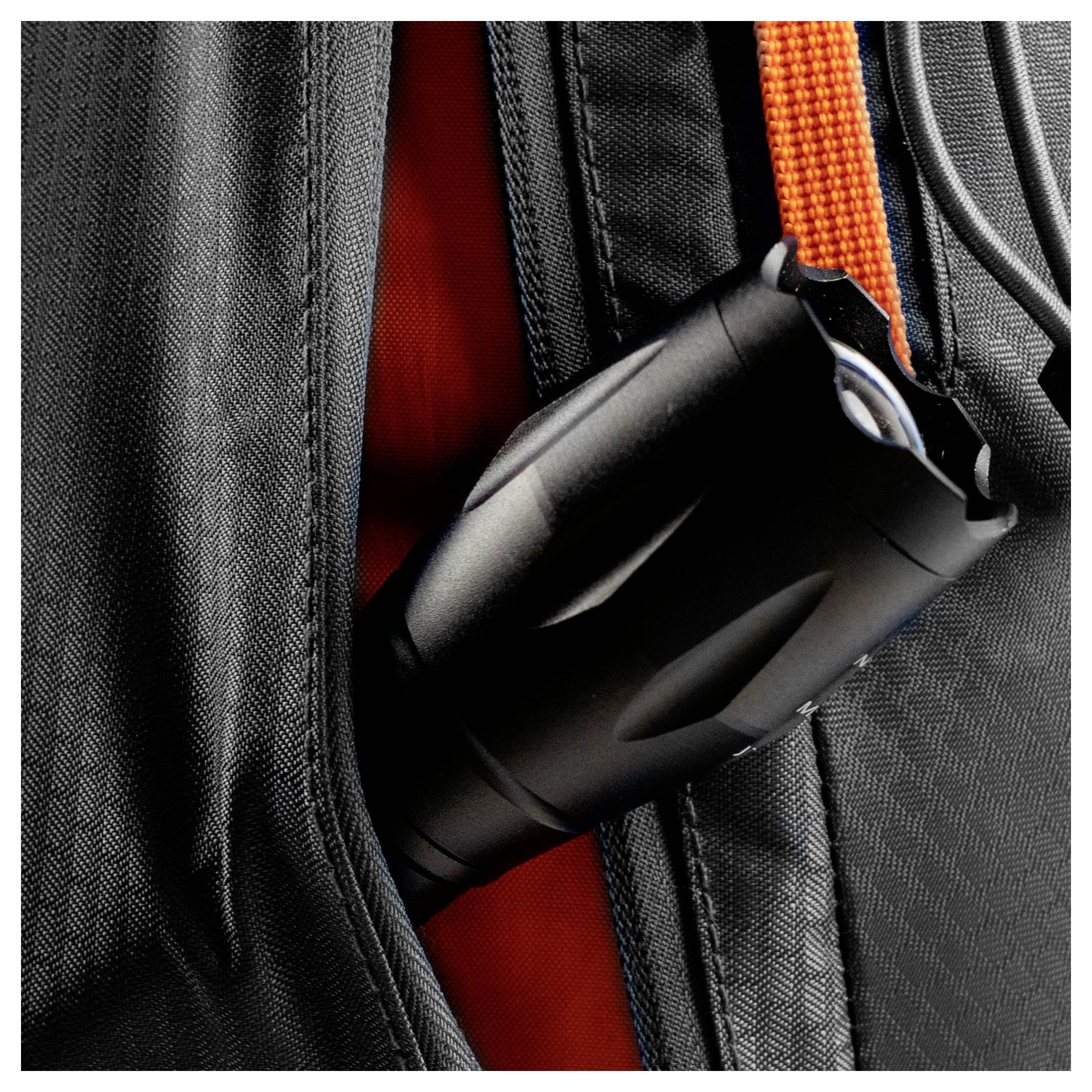 Eine schwarze Taschenlampe, die an einem orangefarbenen Riemen befestigt ist, steckt in einer Tasche einer schwarzen Stofftasche und unterstreicht damit ihre Tragbarkeit und Zugänglichkeit.