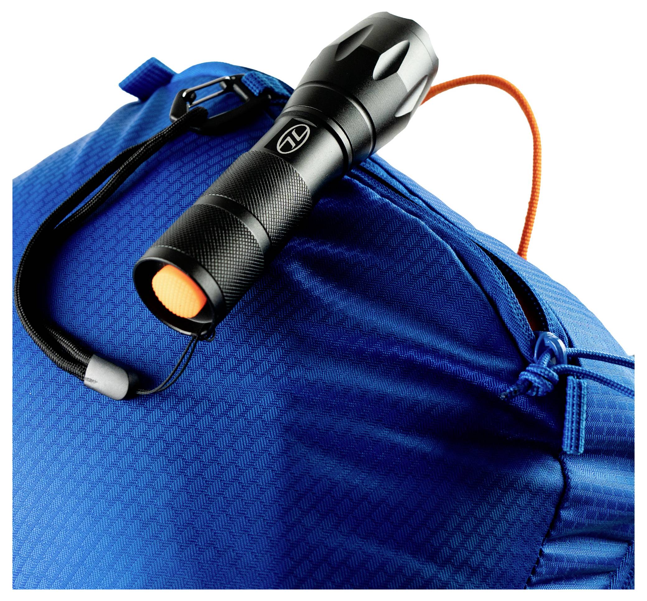Eine schwarze Taschenlampe mit einem orangefarbenen Knopf und Handgelenkriemen, platziert auf einer blauen strukturierten Tasche mit einer orangefarbenen Kordel zum Zuziehen.