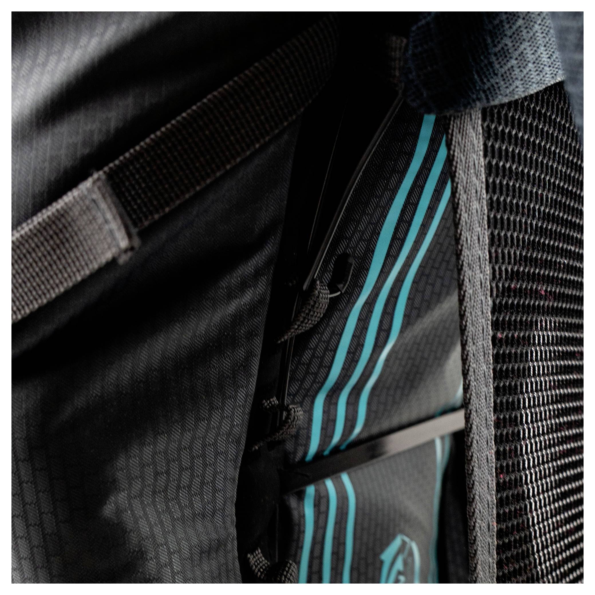 Eine klare Kunststoff-Wasserflasche mit schwarzem Deckel ist in der Seitentasche eines schwarzen Rucksacks verstaut und wird durch verstellbare Riemen gesichert.