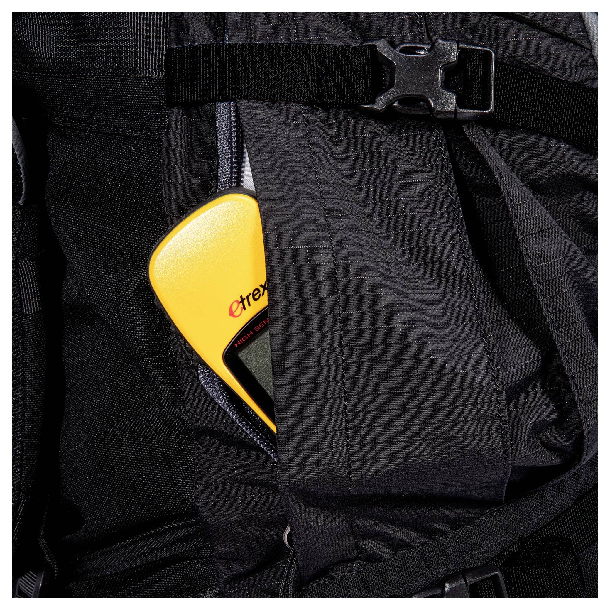 Ein gelbes GPS-Gerät, das teilweise in der Tasche eines schwarzen Rucksacks sichtbar ist.
