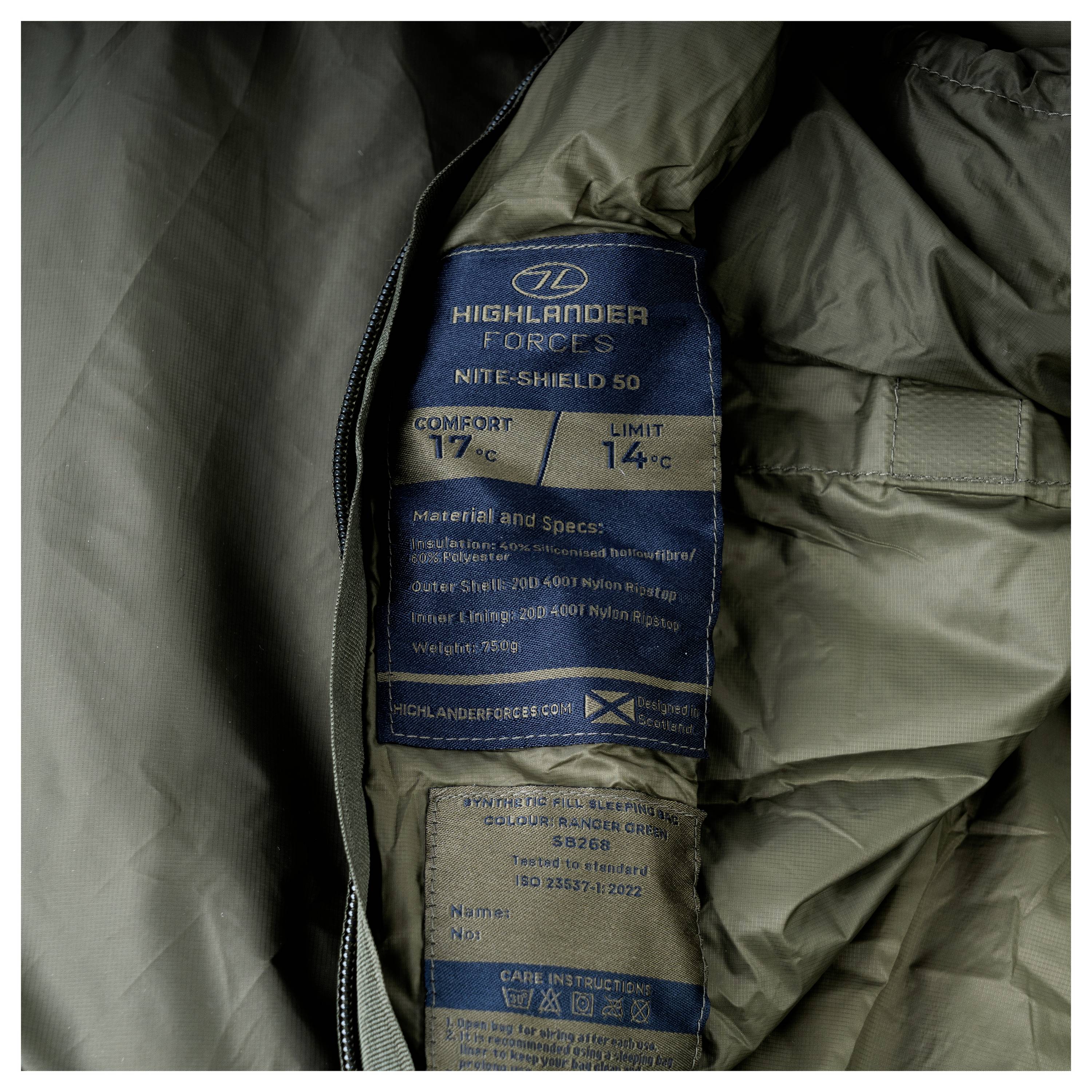 Ein dunkelgrüner, gesteppter Schlafsack, teilweise aufgerollt, mit orangefarbener Innenfutter sichtbar, entworfen für die Verwendung beim Outdoor-Camping.