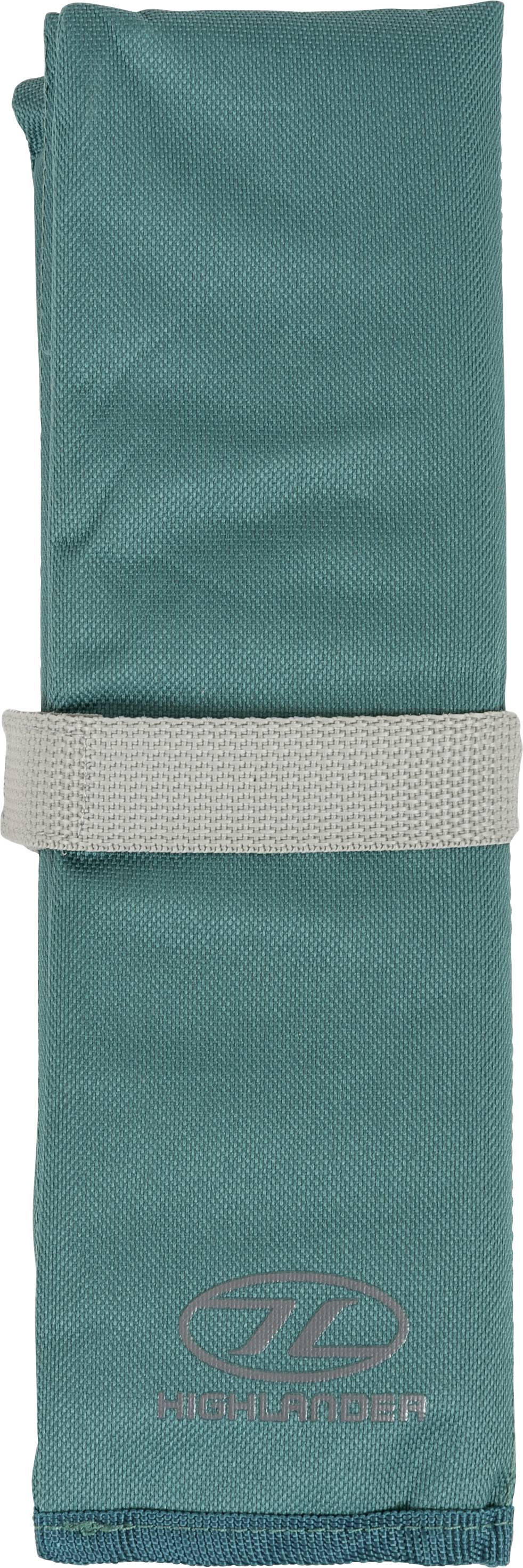 Ein grünes aufgerolltes Handtuch, das mit einem beigen Riemen gesichert ist und ein Logo sowie das Wort 