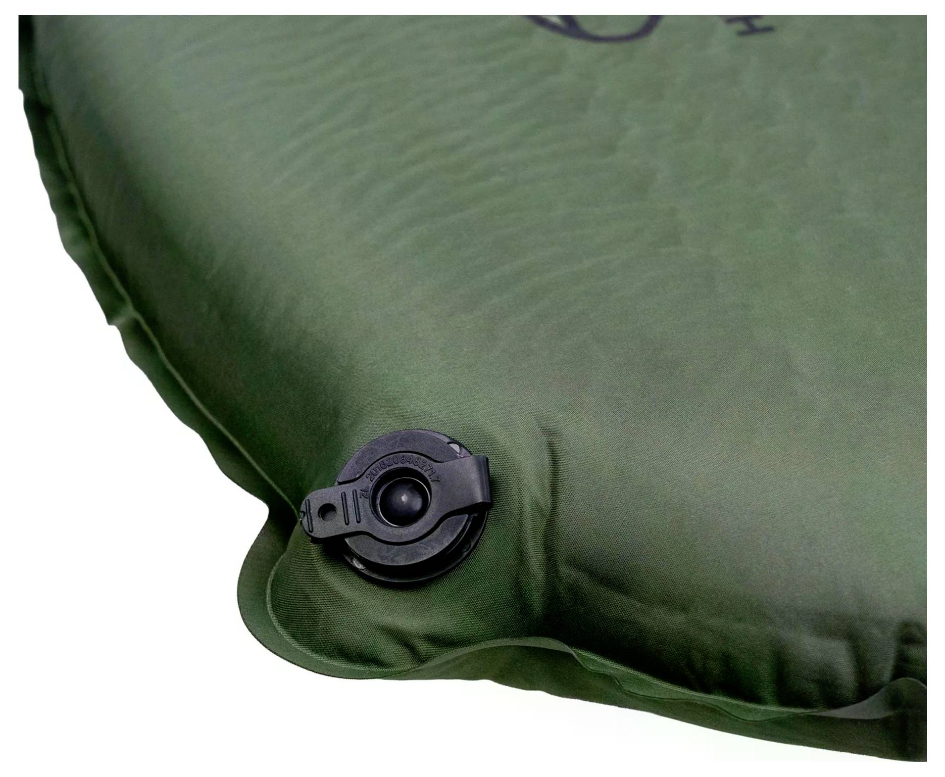 Ein grünes aufblasbares Kissen mit einem schwarzen Luftventil an der Seite, das beim Camping oder für Outdoor-Aktivitäten verwendet wird.