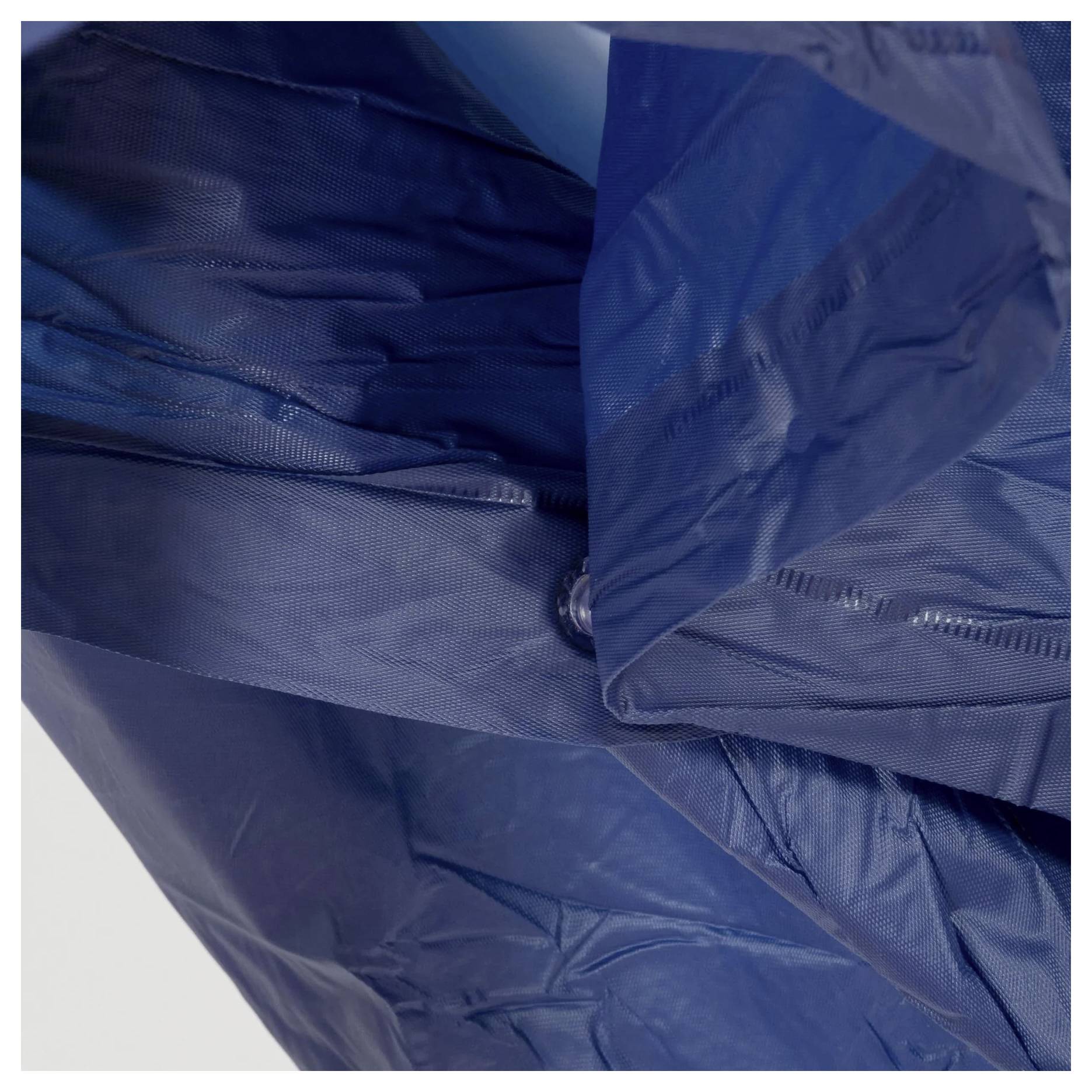 Nahaufnahme eines dunkelblau gefärbten Ripstop-Nylonstoffs mit Nähten und Knopfdetails, die die Textur und die wasserdichten Materialeigenschaften zeigen.