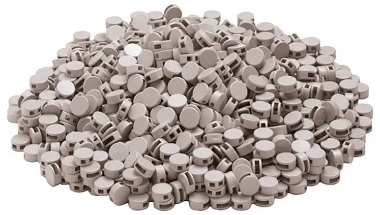 Ein großer Haufen von runden, braunen Tabletten mit einer Rille in der Mitte, die für sprudelnde Getränke verwendet werden.