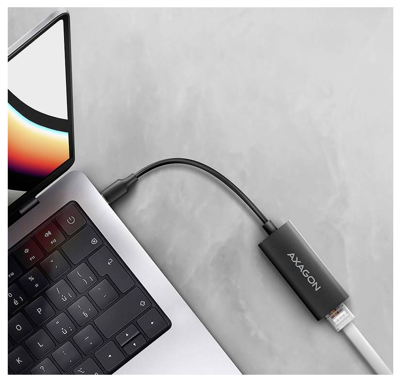 Laptop verbunden mit einem AXAGON USB-C-Adapter/Dongle auf einer grauen Oberfläche.