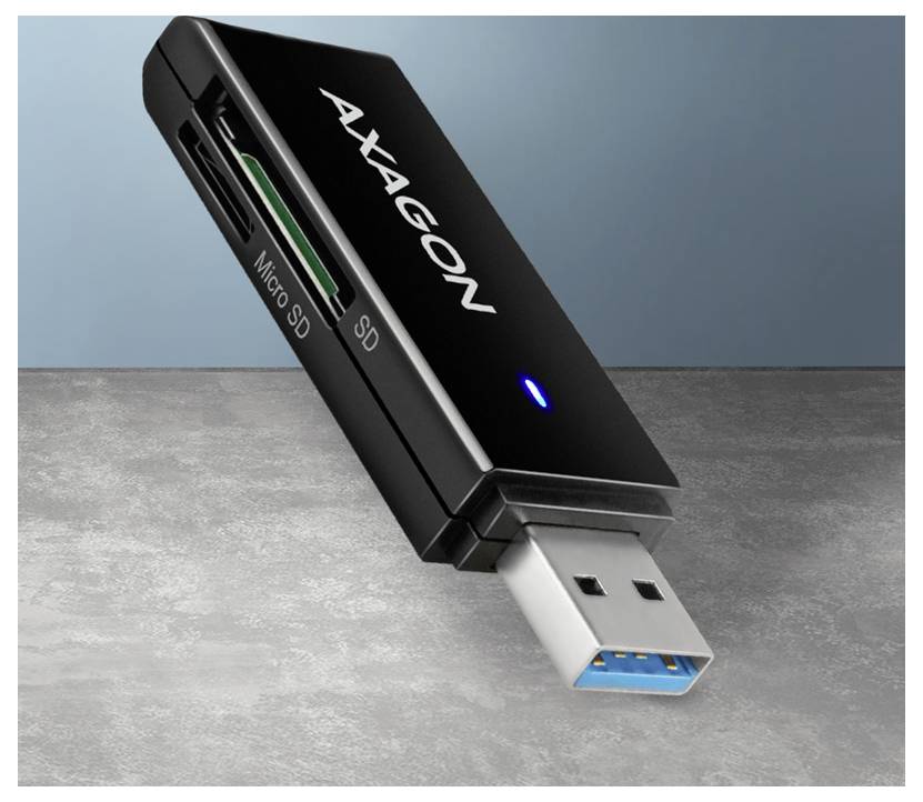 AXAGON USB-Kartenleser mit blauer Anzeigeleuchte und Kappen, der SD- und Micro-SD-Steckplätze auf einer Betonoberfläche zeigt.