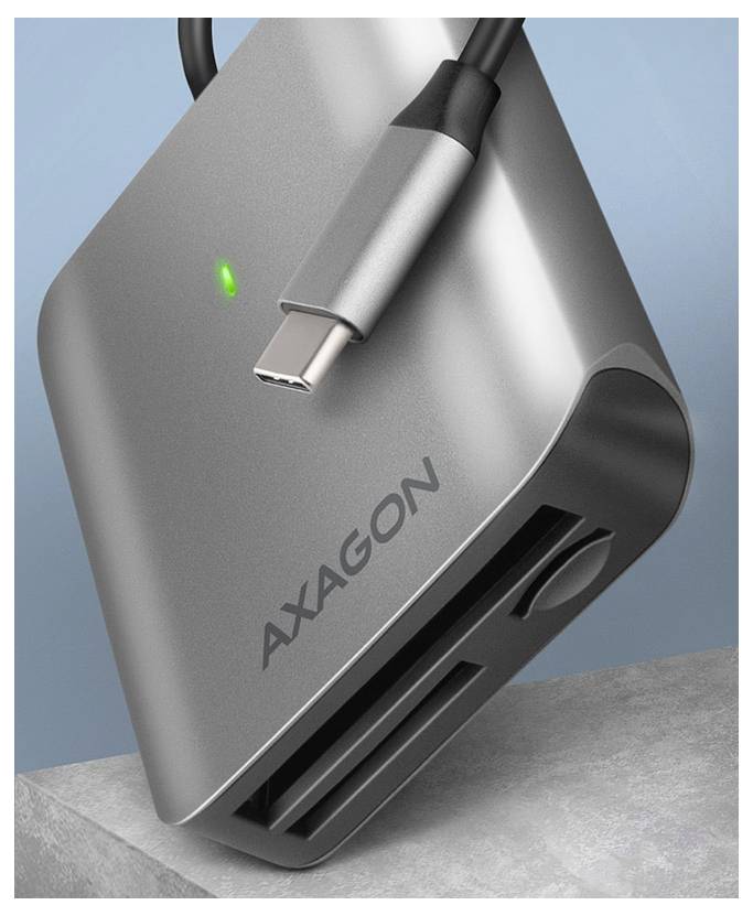 Silberner AXAGON USB-C-Adapter/Dockingstation mit angeschlossenem Kabel, grünem Statuslicht und sichtbaren USB-Anschlüssen auf einer grauen Oberfläche