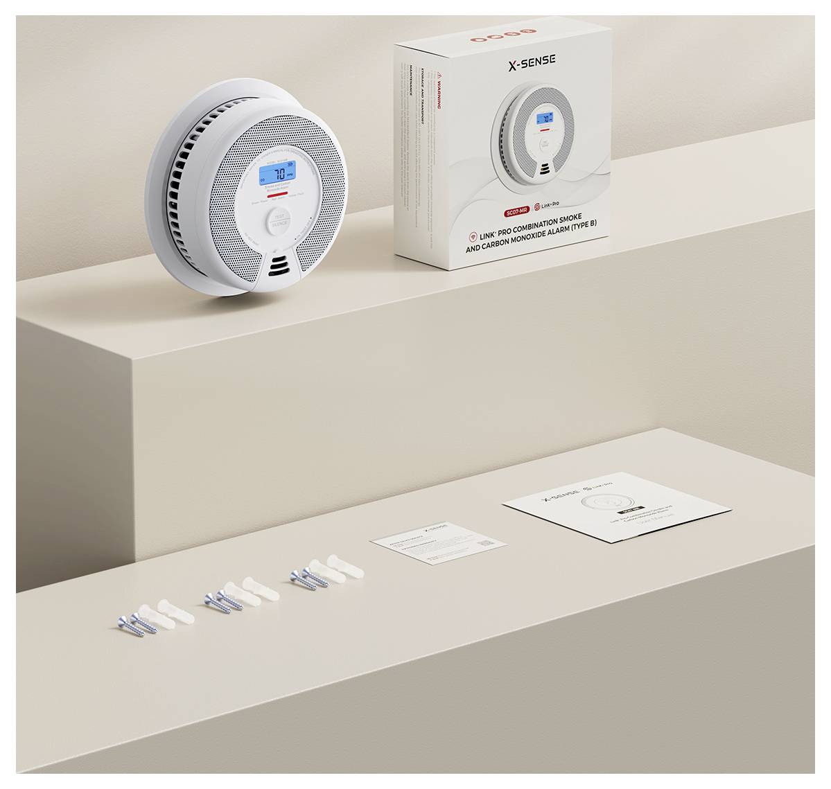 Ein Rauch- und Kohlenmonoxidmelder mit digitalem Display auf einem Regal, neben der Verpackung und Montagezubehör.