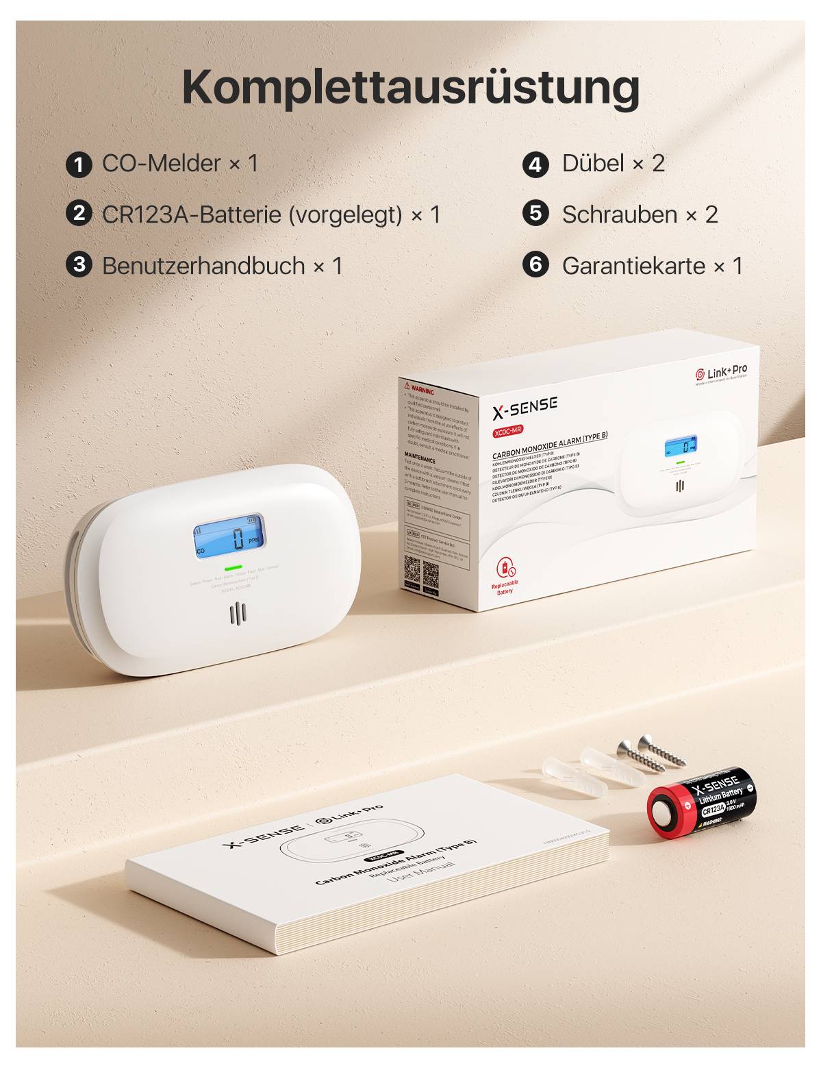 'Komplettausrüstung: 1 CO-Melder, 2 CR123A-Batterien, 1 Benutzerhandbuch, 4 Dübel, 2 Schrauben, 6 Garantiekarte.' CO-Melder und Verpackung abgebildet.