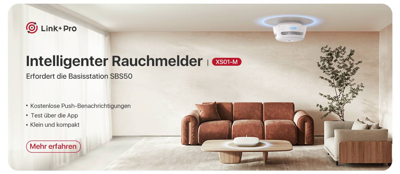 Wohnzimmer mit Sofa und Tisch, intelligentem Rauchmelder an der Decke. Text: 'Intelligenter Rauchmelder XS01-M, Basisstation benötigt'.