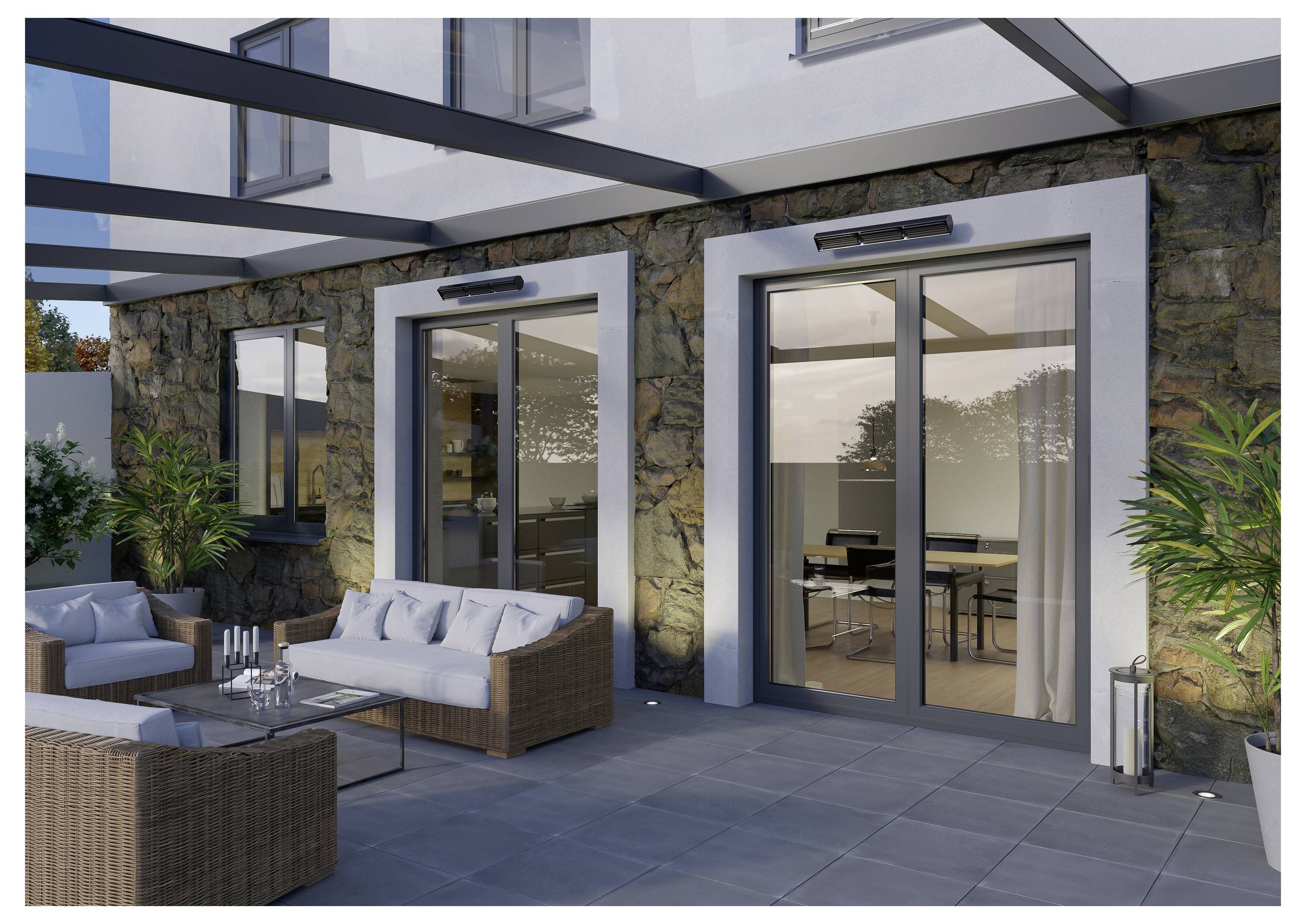 Terrasse im Freien mit Korbmöbeln, Glastisch und Topfpflanzen, angrenzend an ein Gebäude mit großen Glasschiebetüren, die zu einem Innenraum führen.