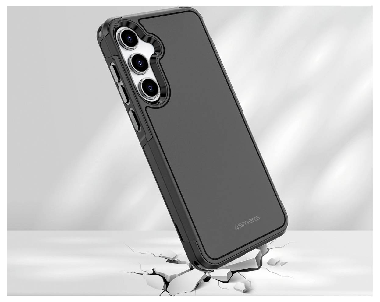 Ein Smartphone mit schwarzem Gehäuse steht aufrecht auf einer weißen Oberfläche und verursacht sichtbare Risse darunter, was die Schlagfestigkeit hervorhebt.