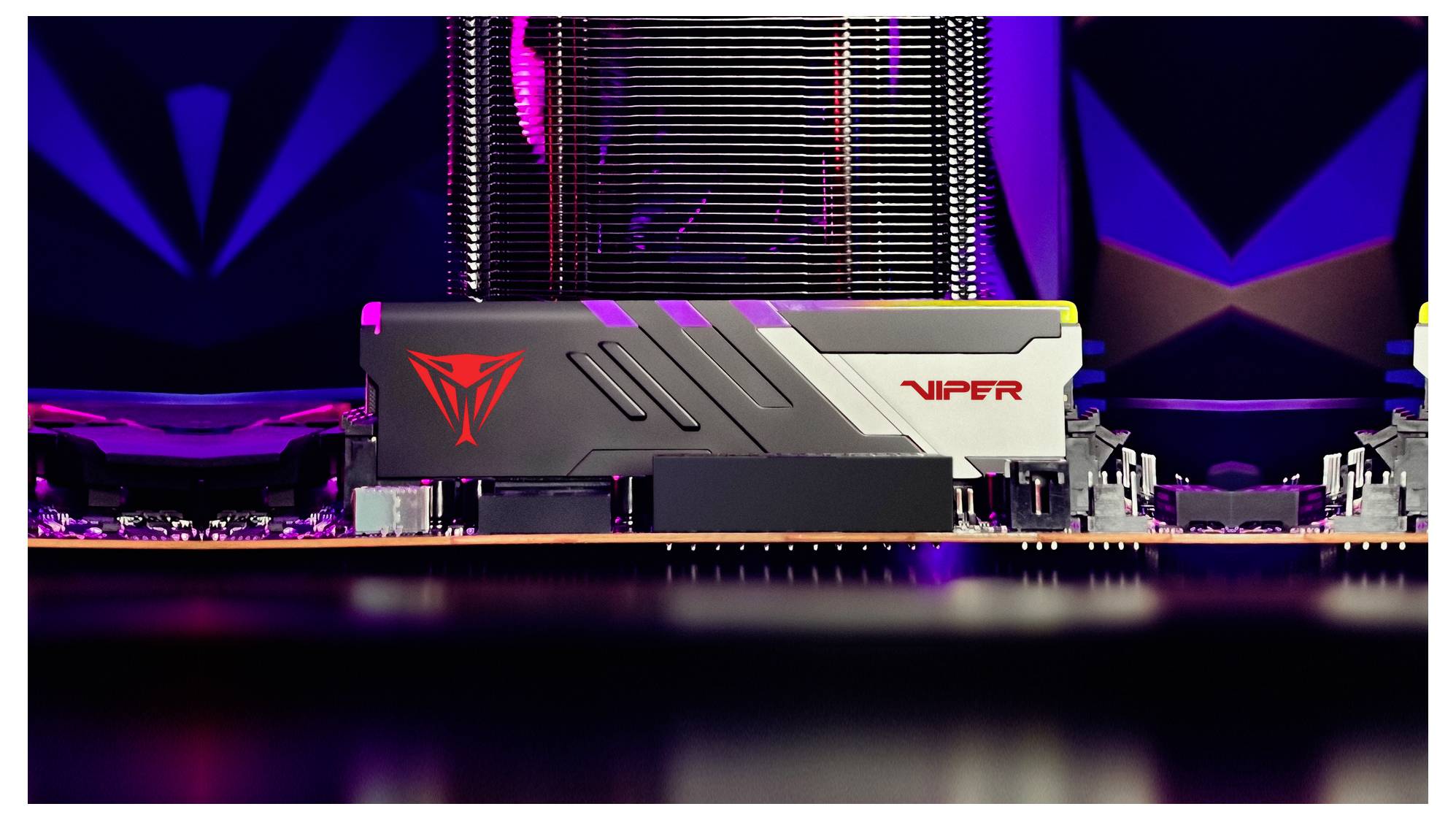 Eine Nahaufnahme einer Computerplatine mit einem Viper-RAM-Modul mit schlankem Design und rotem Logo, vor einem dunklen, technisch gestalteten Hintergrund.