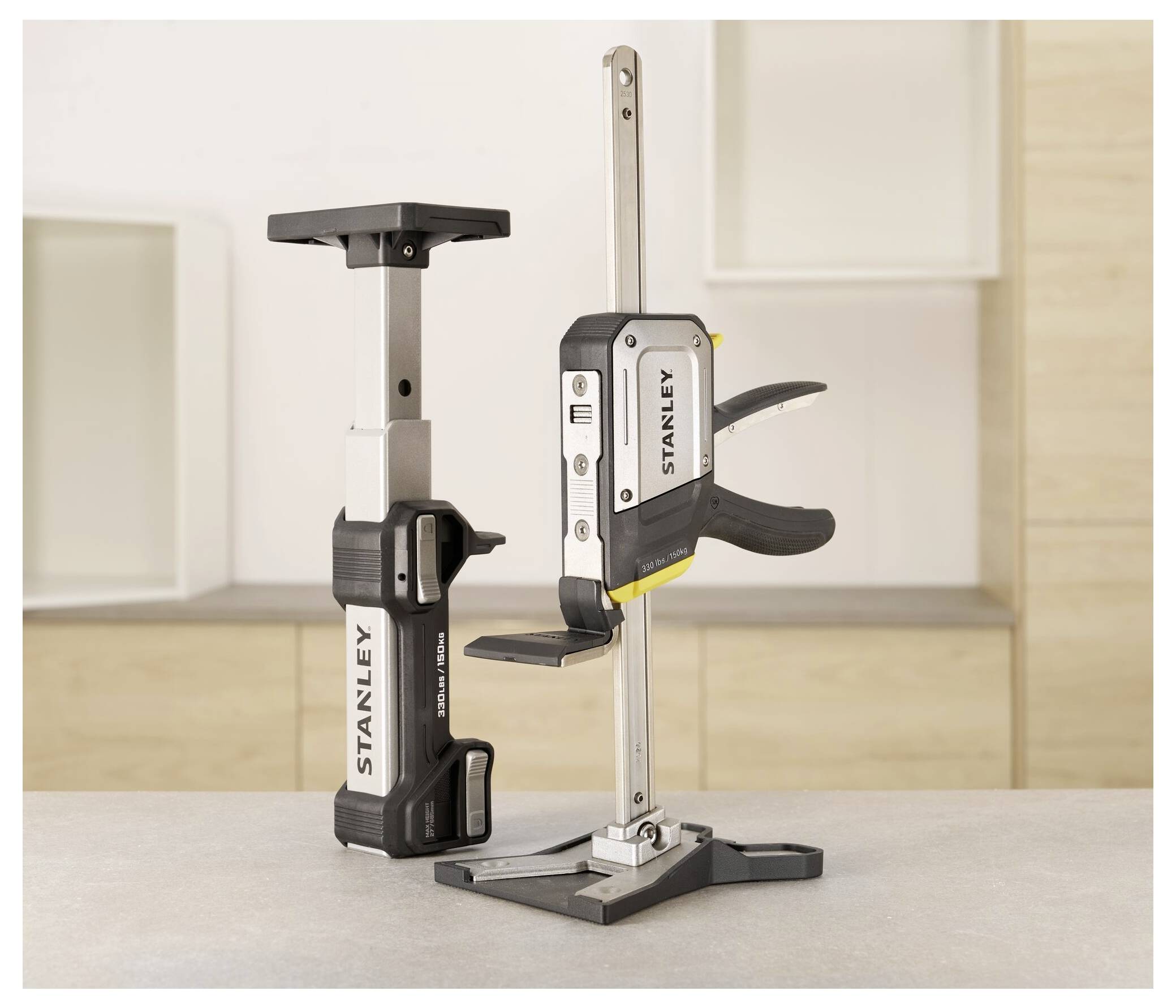 Stanley-Spannwerkzeuge auf einem Holztisch, aufrecht positioniert mit beigem Küchenhintergrund; verwendet zum Befestigen von Materialien.