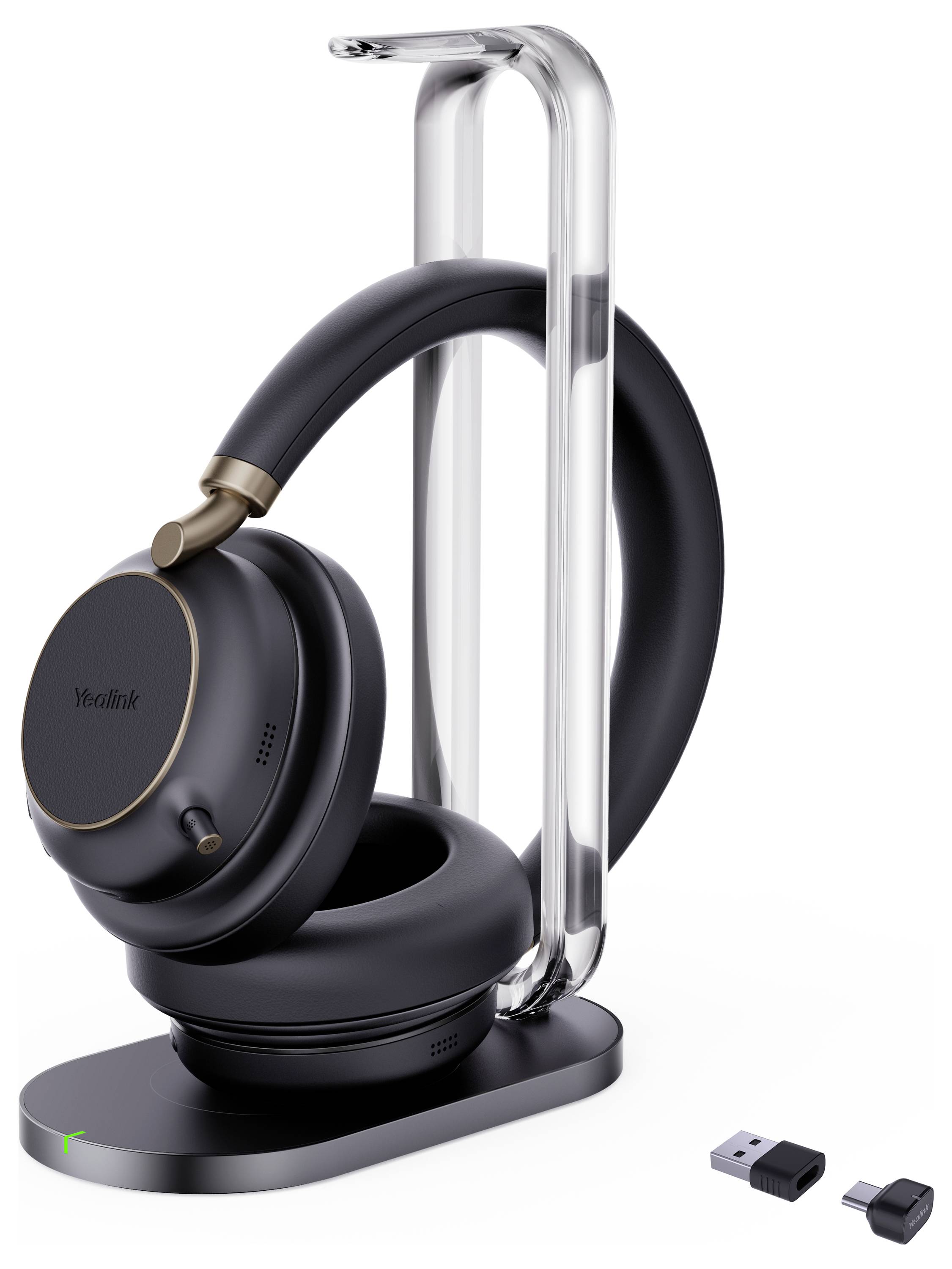 Ein elegantes schwarzes Headset mit goldenen Akzenten wird auf einem modernen, transparenten Ständer präsentiert. Zwei kleine USB-Geräte sind daneben angeordnet.