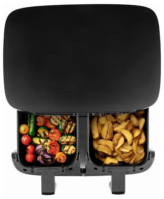 Eine schwarze Heißluftfritteuse mit zwei Fächern; eines enthält gegrilltes Gemüse und das andere enthält goldbraune Kartoffelspalten.