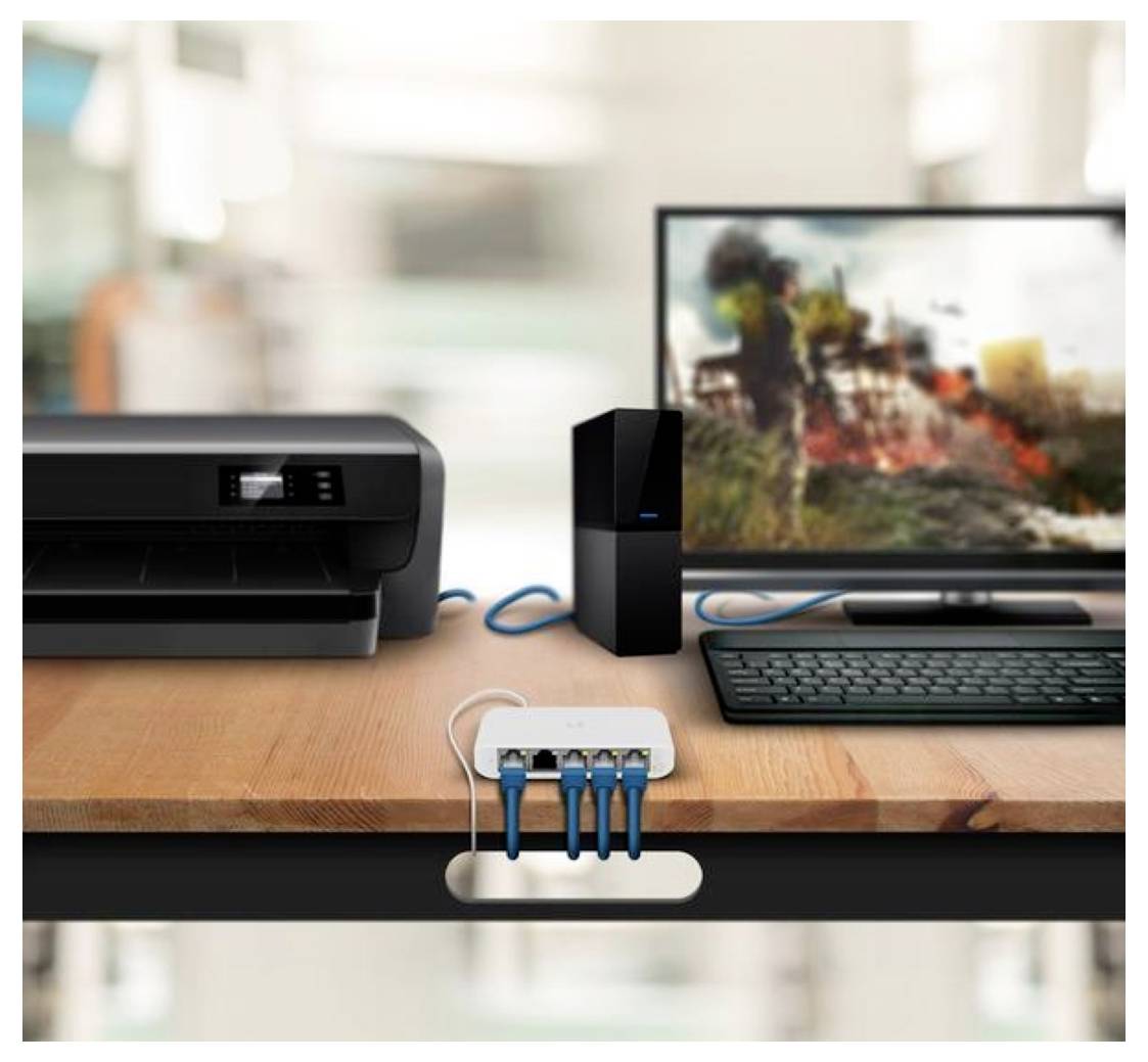 Ein Schreibtisch mit einem Desktop-Computer, einem Drucker und einem Netzwerk-Hub. Blaue Kabel verbinden die Geräte und zeigen ein Home-Office-Setup.