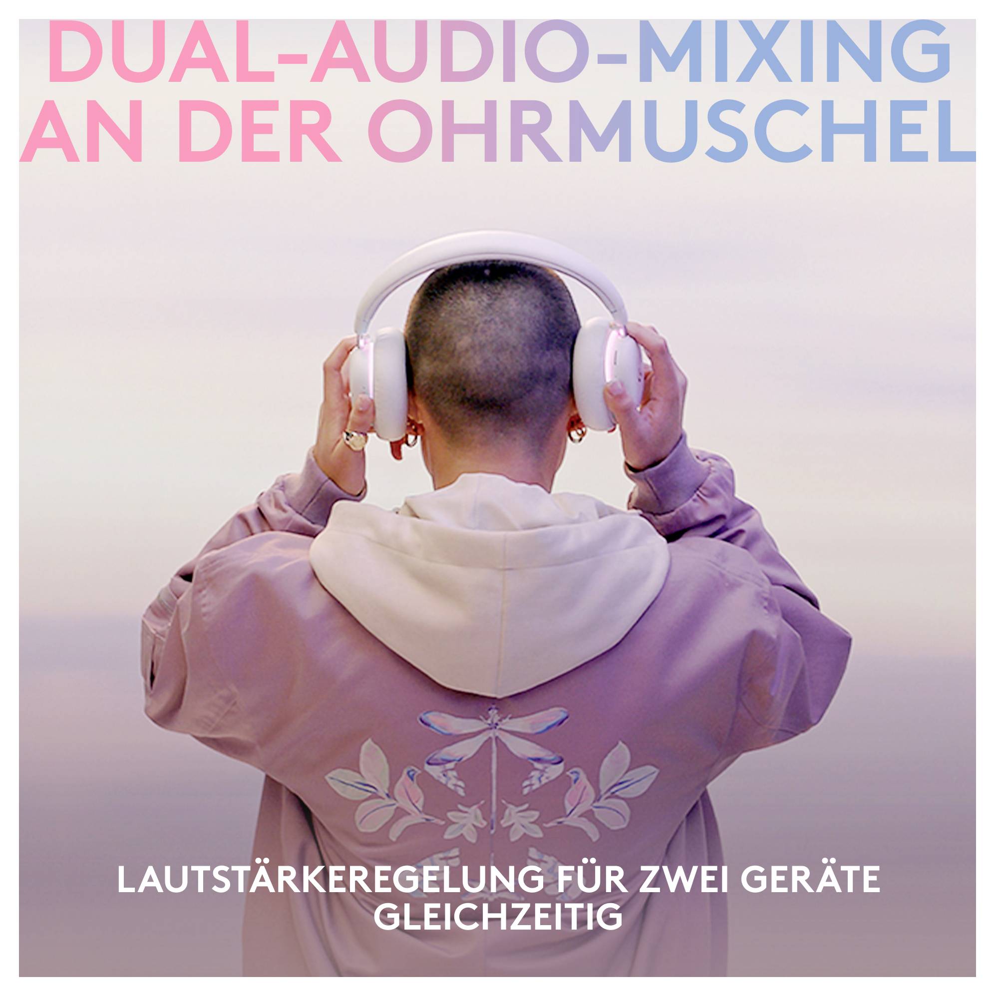 Person von hinten gesehen, trägt weiße Kopfhörer und einen rosa Hoodie mit deutschem Text „DUAL-AUDIO-MIXING AN DER OHRMUSCHEL