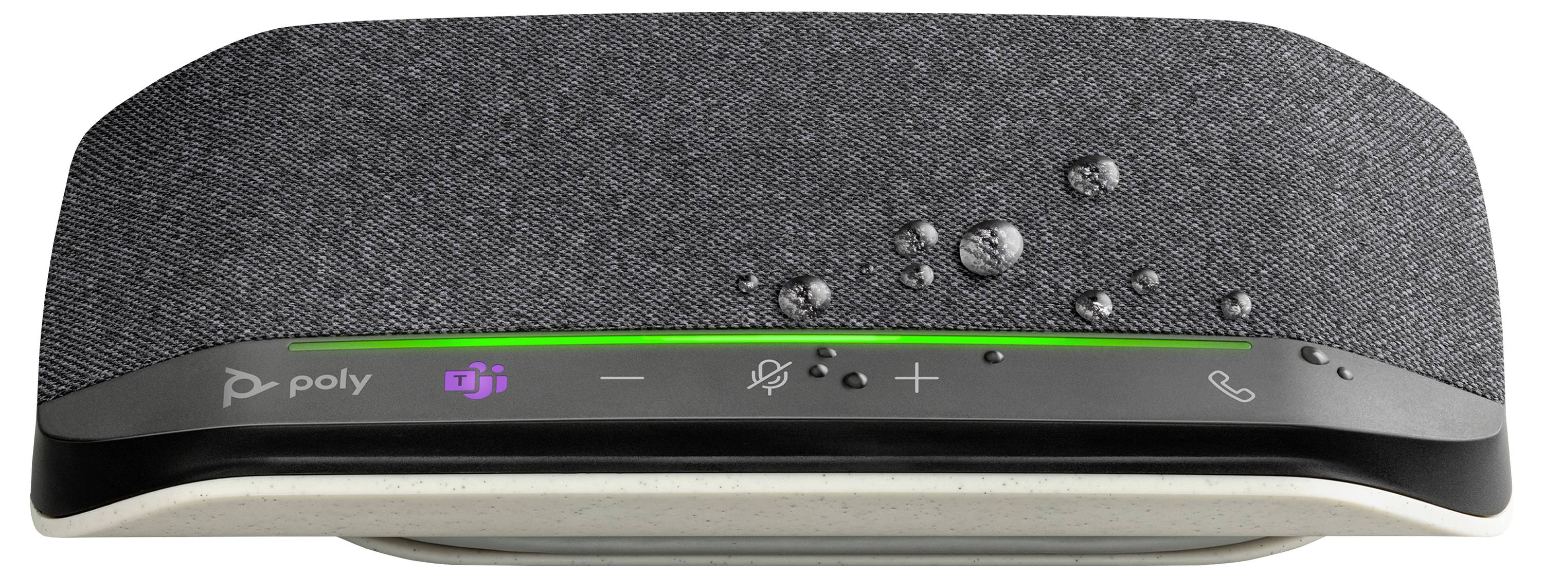 Nahaufnahme eines Poly-Speakerphones mit Microsoft Teams-Schaltfläche, Stummschalt-, Lautstärke- und Anrufsteuerungen auf einem stoffbezogenen Gerät.