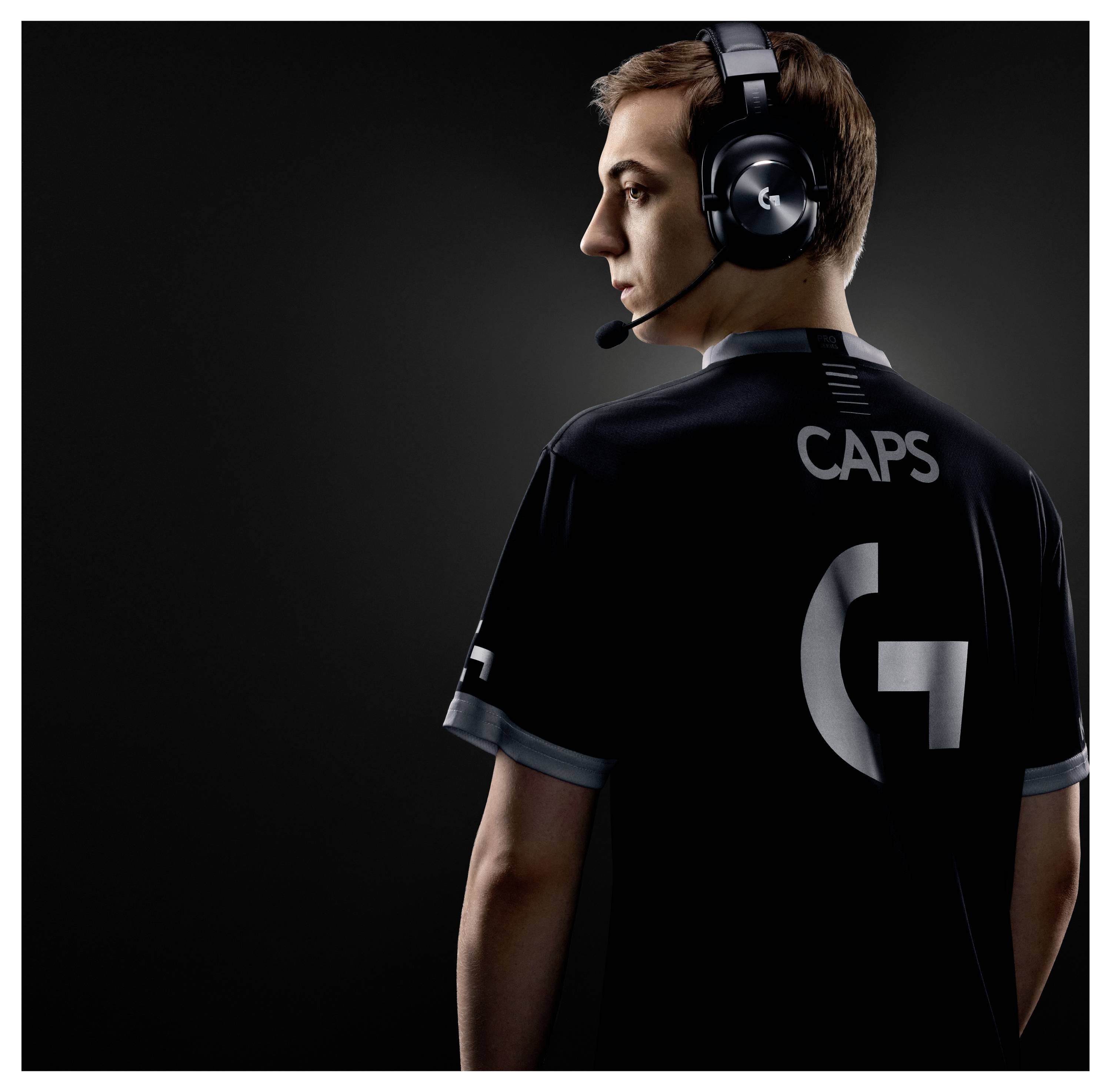 Rückenansicht eines Gamers, der ein Headset trägt und ein schwarzes Trikot mit der Aufschrift „CAPS