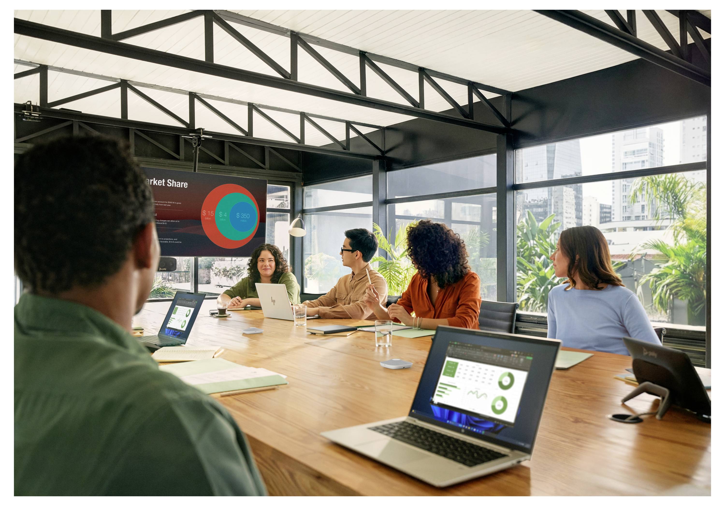 Besprechungsraum mit vielfältigem Team um einen Konferenztisch, das Laptops und Tablets nutzt, während ein Präsentator neben einer Wandanzeige mit Diagrammen steht; deutscher Text bewirbt einfache Einrichtung und benutzerfreundliche Bedienung.