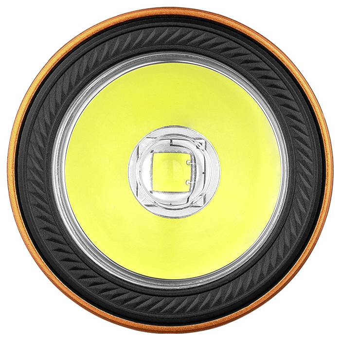 Nahaufnahme eines Taschenlampenreflektors mit einem orange gefärbten äußeren Ring, schwarzem inneren Ring und leuchtend gelbem Zentrum.
