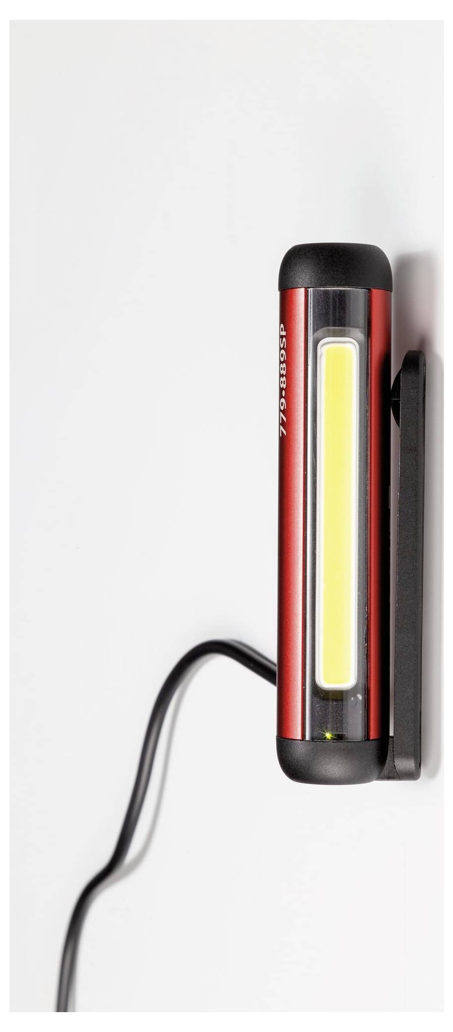 Ein Bauarbeiter benutzt eine Kreissäge, um ein großes Holzbrett zu schneiden, während er Schutzausrüstung trägt, einschließlich eines Helms und einer Schutzbrille, in einem schwach beleuchteten Arbeitsbereich.