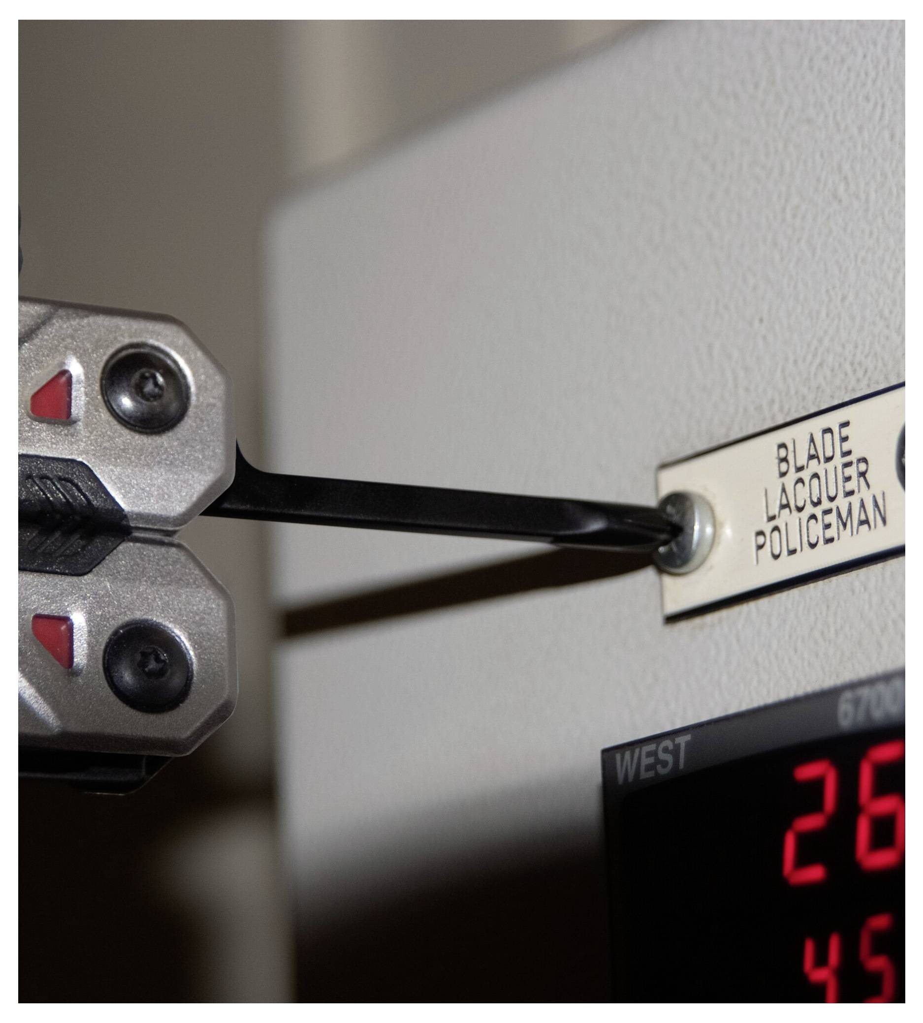 Ein rotes zylindrisches Gerät mit einem schwarzen Clip an der Seite, das Zertifizierungssymbole und Spannungsinformationen anzeigt.