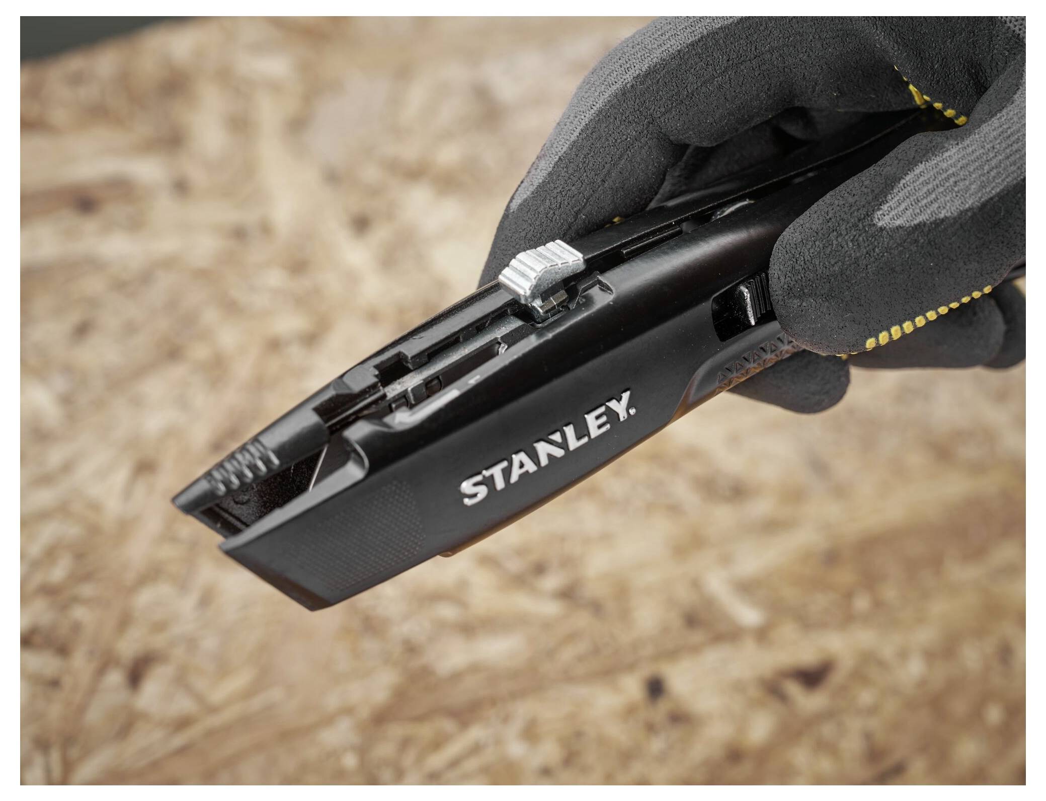 Ein Bauarbeiter in einer leuchtend gelben Sicherheitsweste benutzt eine Kreissäge, um Holz auf einer Baustelle zu schneiden, umgeben von hölzernen Rahmenstrukturen.