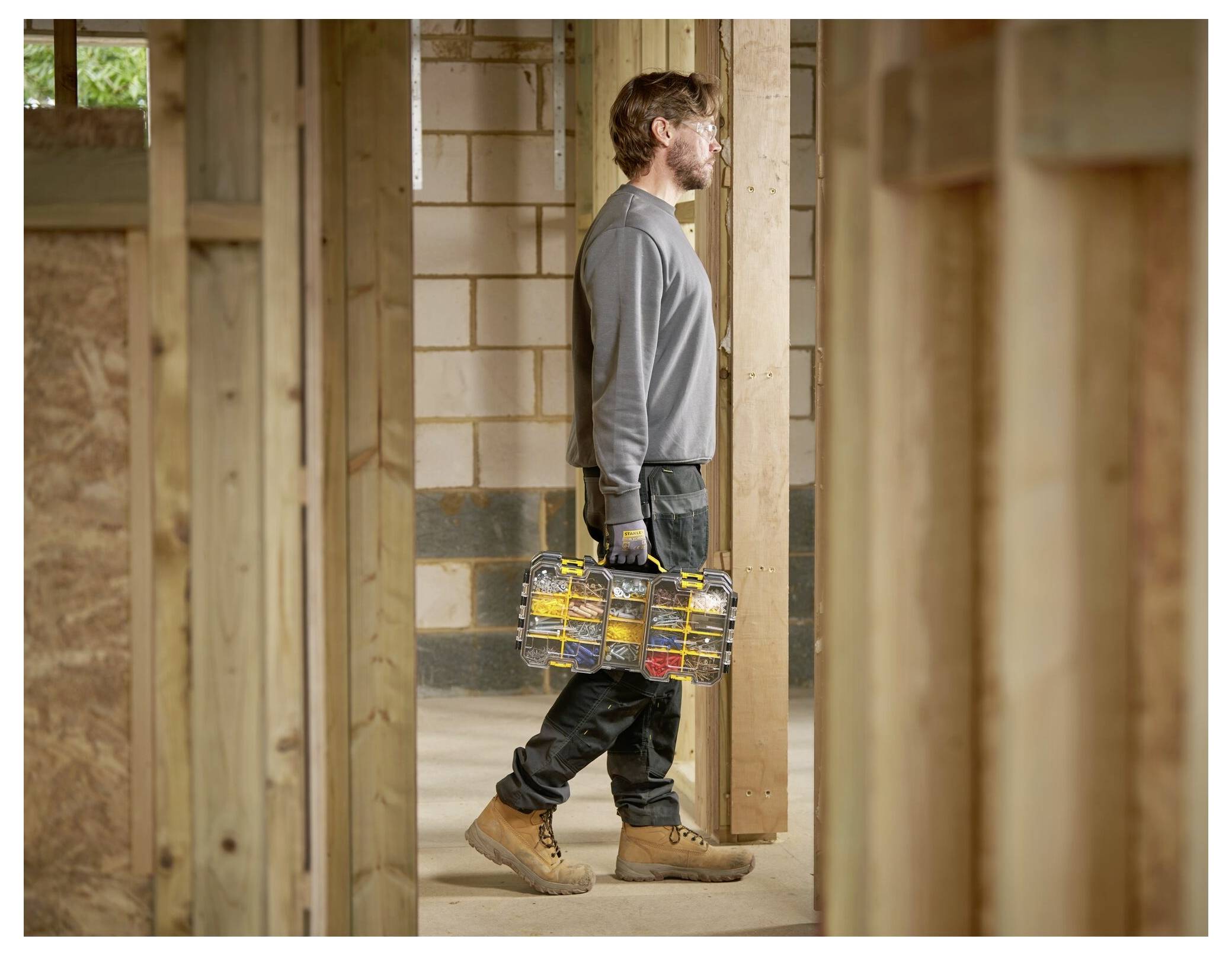 Eine rot-schwarz karierte Werkzeugkiste, offen zur Schau gestellt mit einem Satz Steckschlüsseln, einem Schraubendreher und verschiedenen Bits, die ordentlich angeordnet sind.