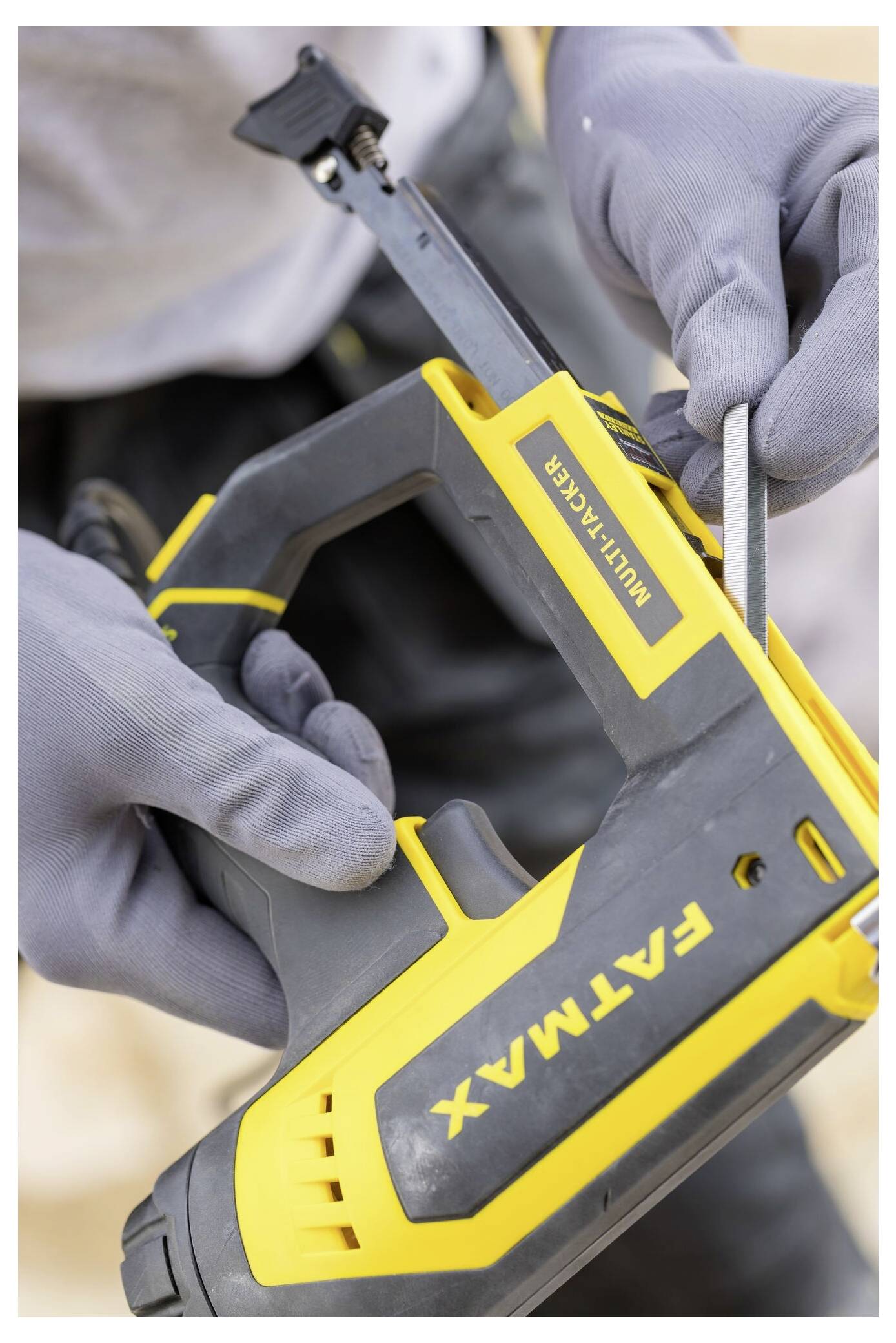 Eine Person, die mit einem Stahllineal einen hölzernen Rahmen misst, trägt Handschuhe und befindet sich in einem Innenraum. Der Rahmen besteht aus vertikalen Holzbalken.