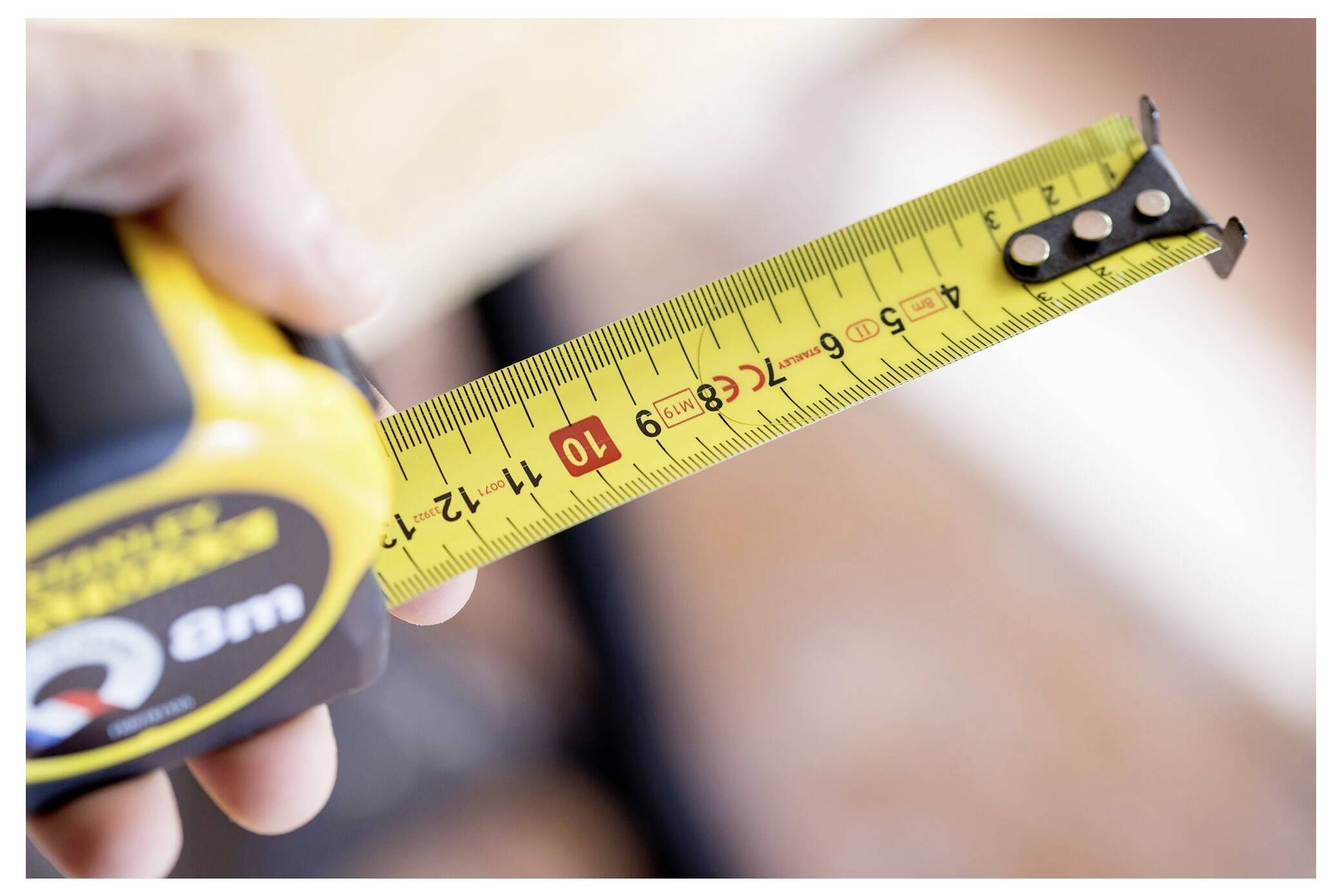 Zwei behandschuhte Hände halten eine gelb-graue Batterie mit der Aufschrift „Stanley Fatmax V20 2.0Ah Lithium Battery