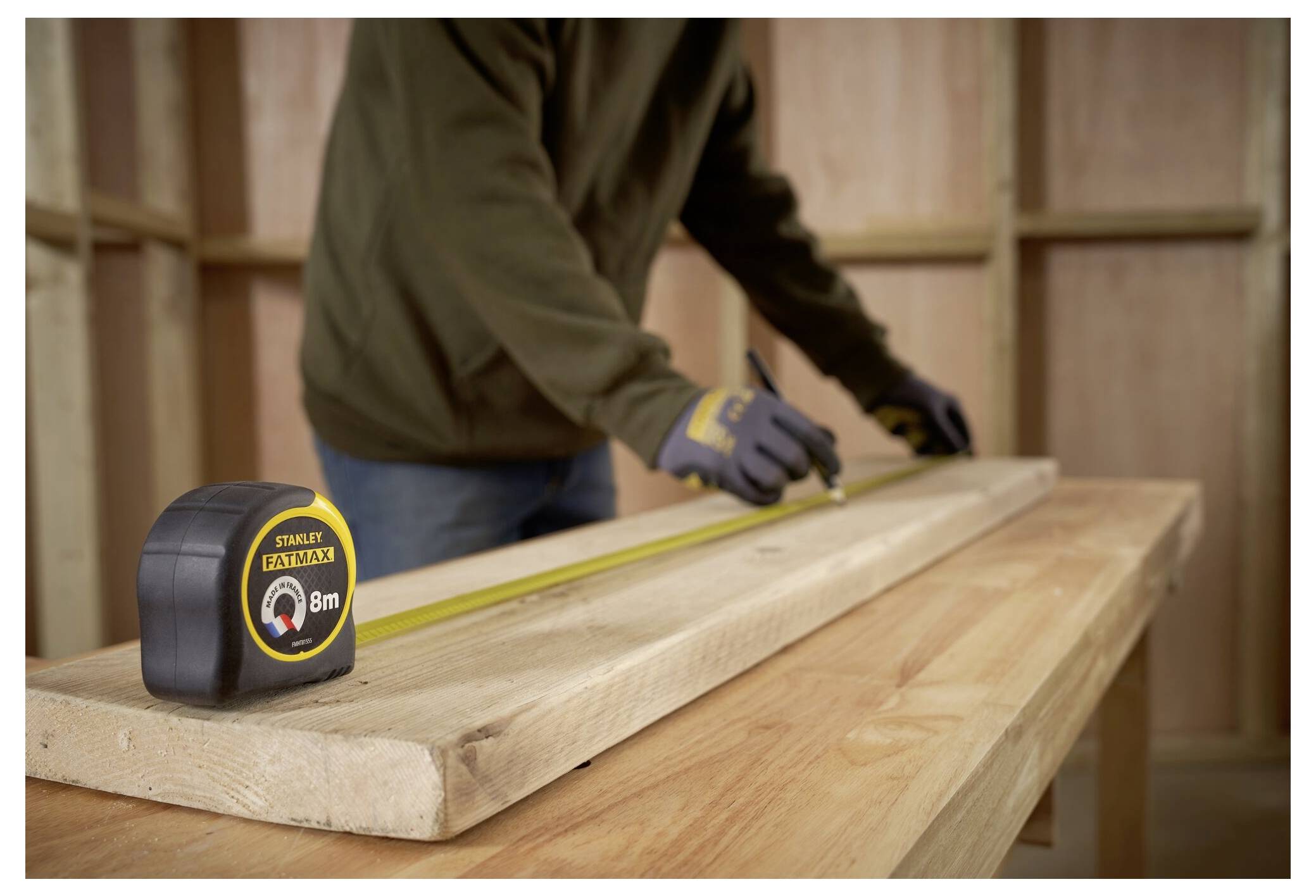 Eine Person mit Handschuhen führt eine Klammer in eine gelb-schwarze Klammermaschine ein, die mit „FATMAX MULTI-TACKER