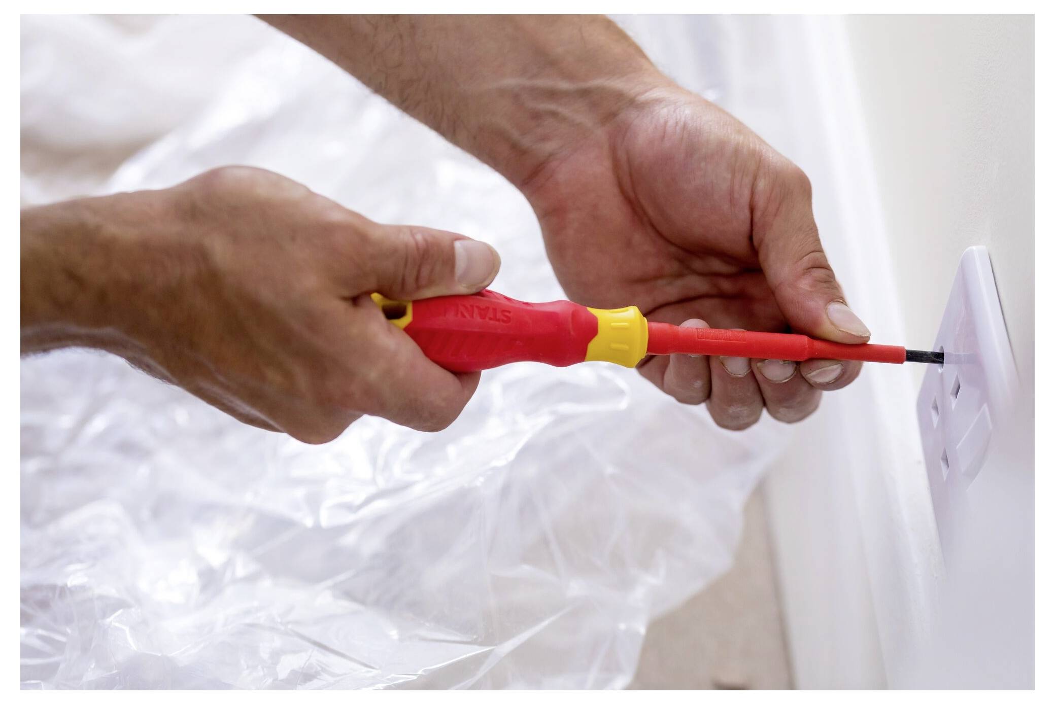 Eine Person in Winterkleidung nutzt einen Schneefräser, um Schnee in einem Waldgebiet zu räumen, während Schnee in die Luft spritzt, umgeben von hohen Kiefernbäumen.