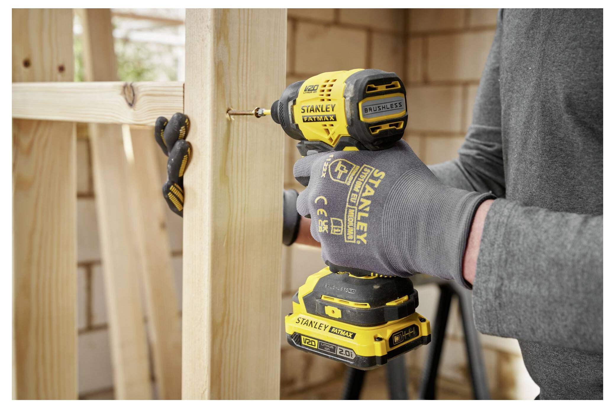 Eine Person, die einen gelben Schneefräser auf schneebedecktem Boden bedient und den Griff ergreift, um die Auswurfrinne zu lenken.