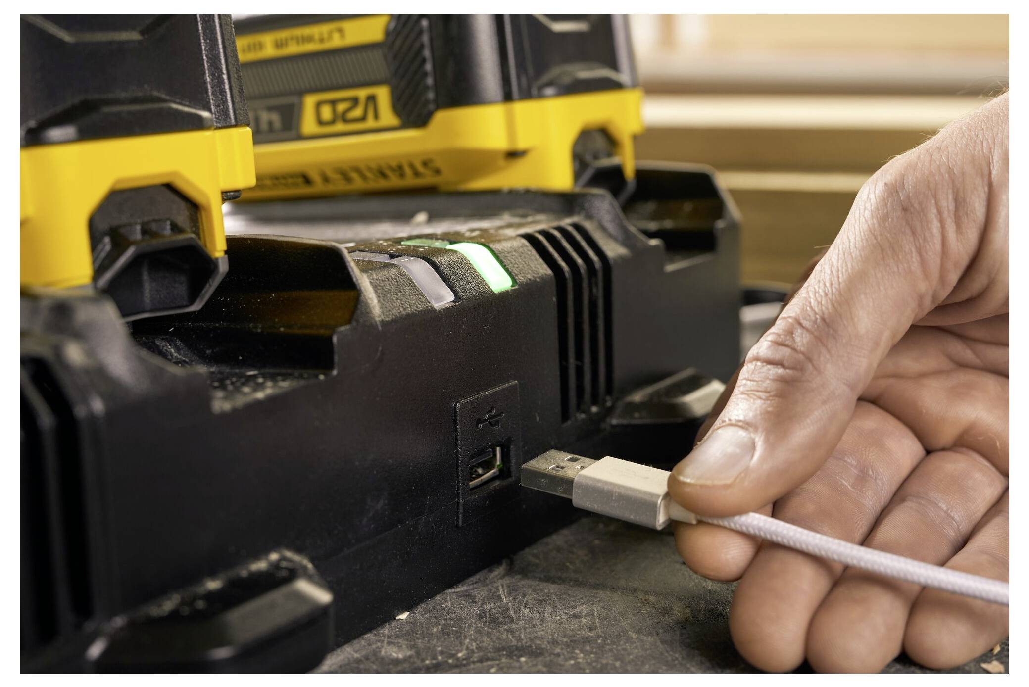 Ein gelbes Messstab erstreckt sich über Holzbalken und zeigt eine Messung in einer Baustelle an.