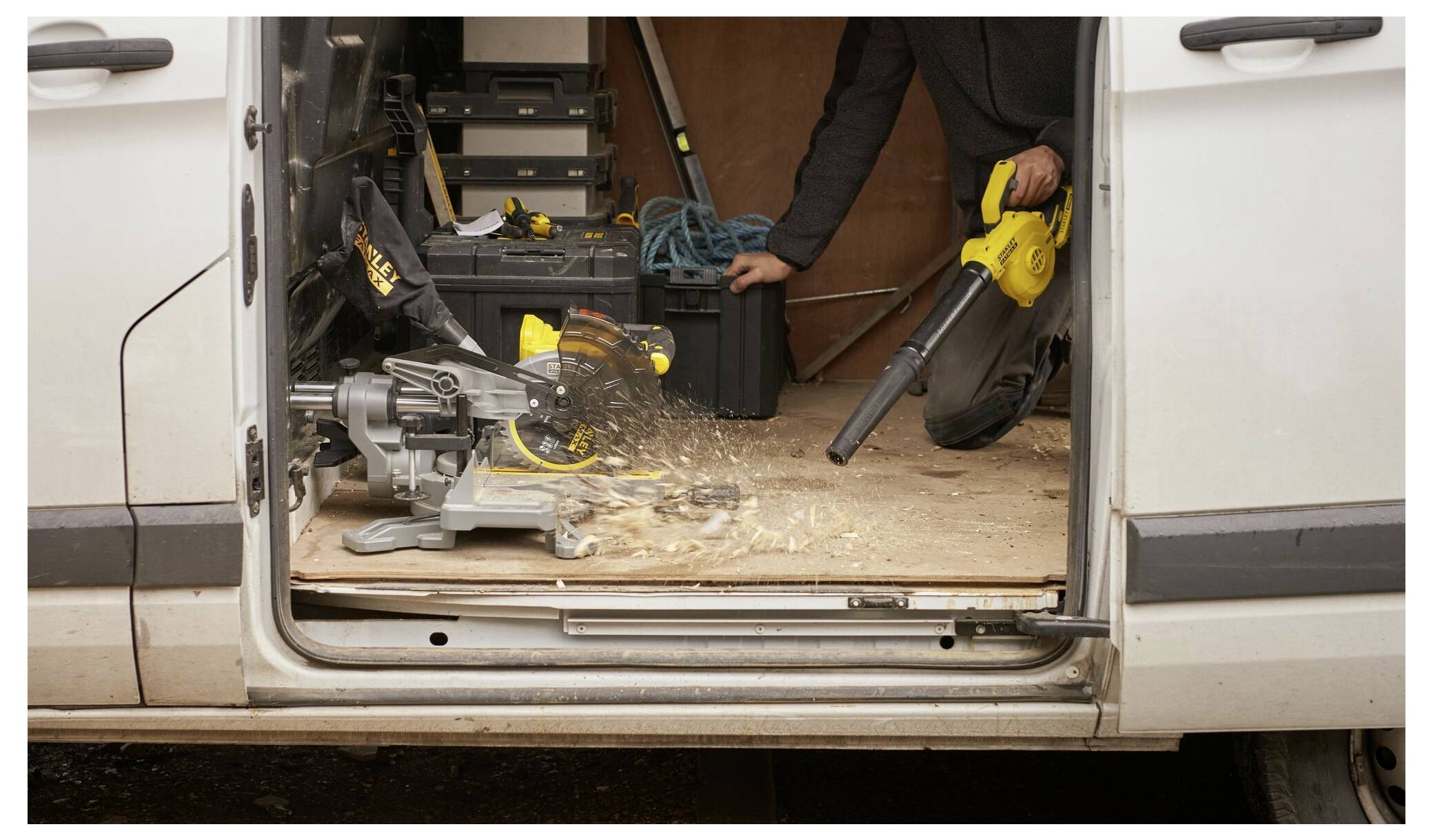 Ein gelbes Elektrowerkzeug schleieft Metall auf einer hölzernen Werkbank und sprüht dabei Funken. Das Metallstück ist sicher eingespannt.