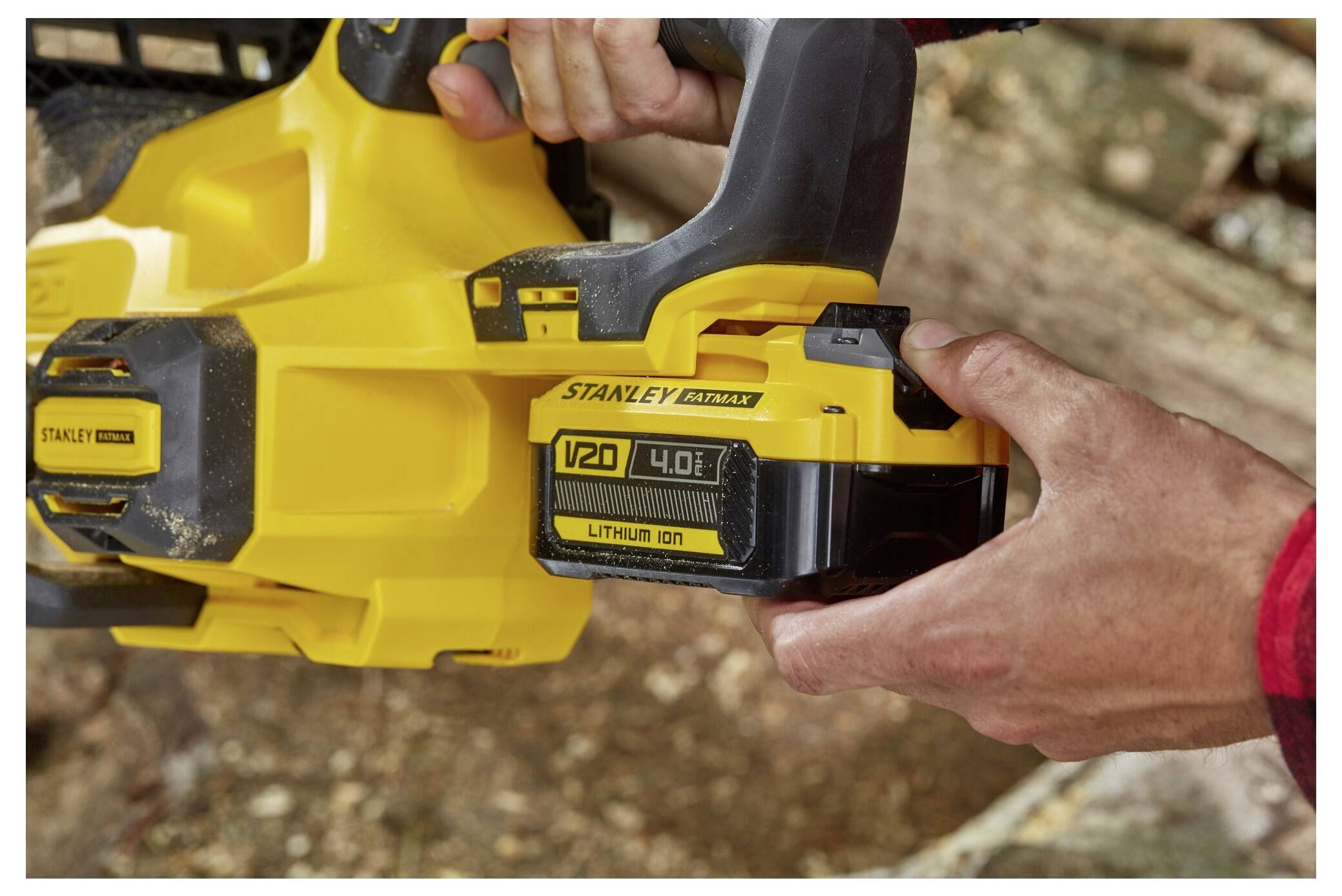 Ein Mann benutzt einen gelben Elektroschrauber, um ein Loch in eine Betonwand zu bohren. Er trägt eine Schutzbrille und Handschuhe und konzentriert sich intensiv auf die Aufgabe.