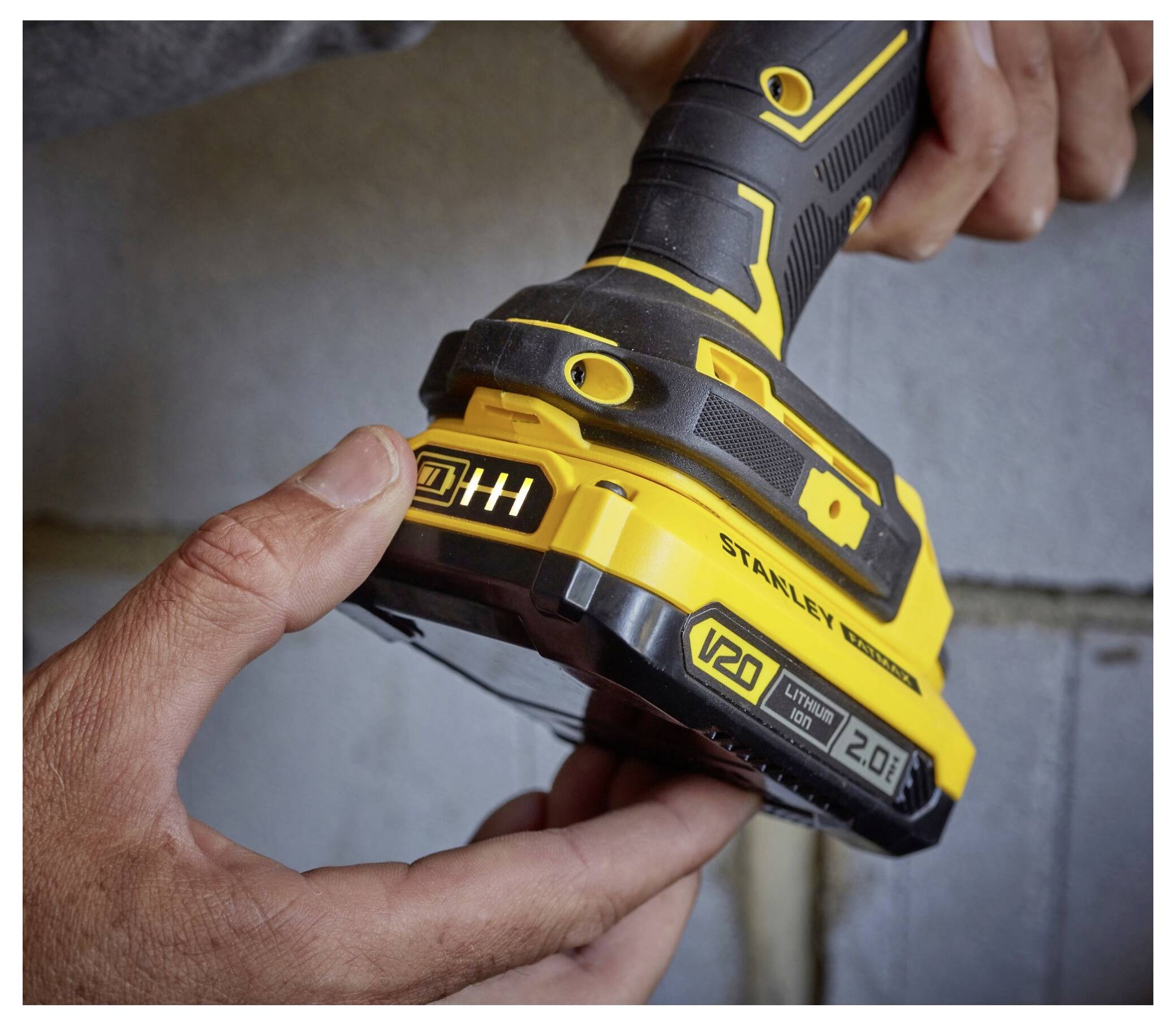 Eine Lötkolben der Marke 'Stanley' in gelb und schwarz mit Spiralhalter und angeschlossenem Stromkabel.