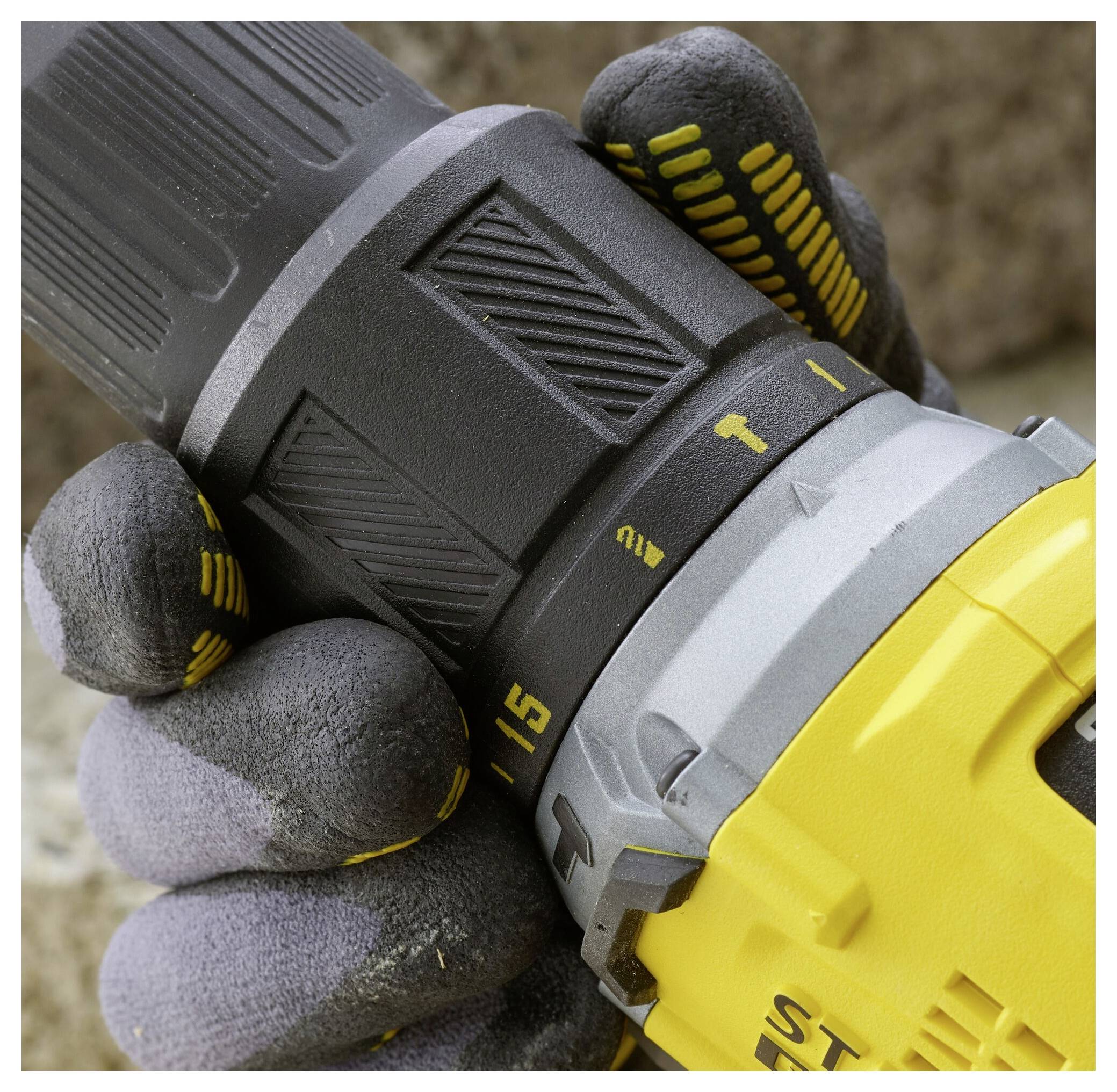 Eine behandschuhte Hand stellt die Drehmomenteinstellung eines Elektroschlüssels ein. Der Bohrer ist schwarz und gelb, mit strukturierten Griffen und sichtbaren nummerierten Einstellungen.