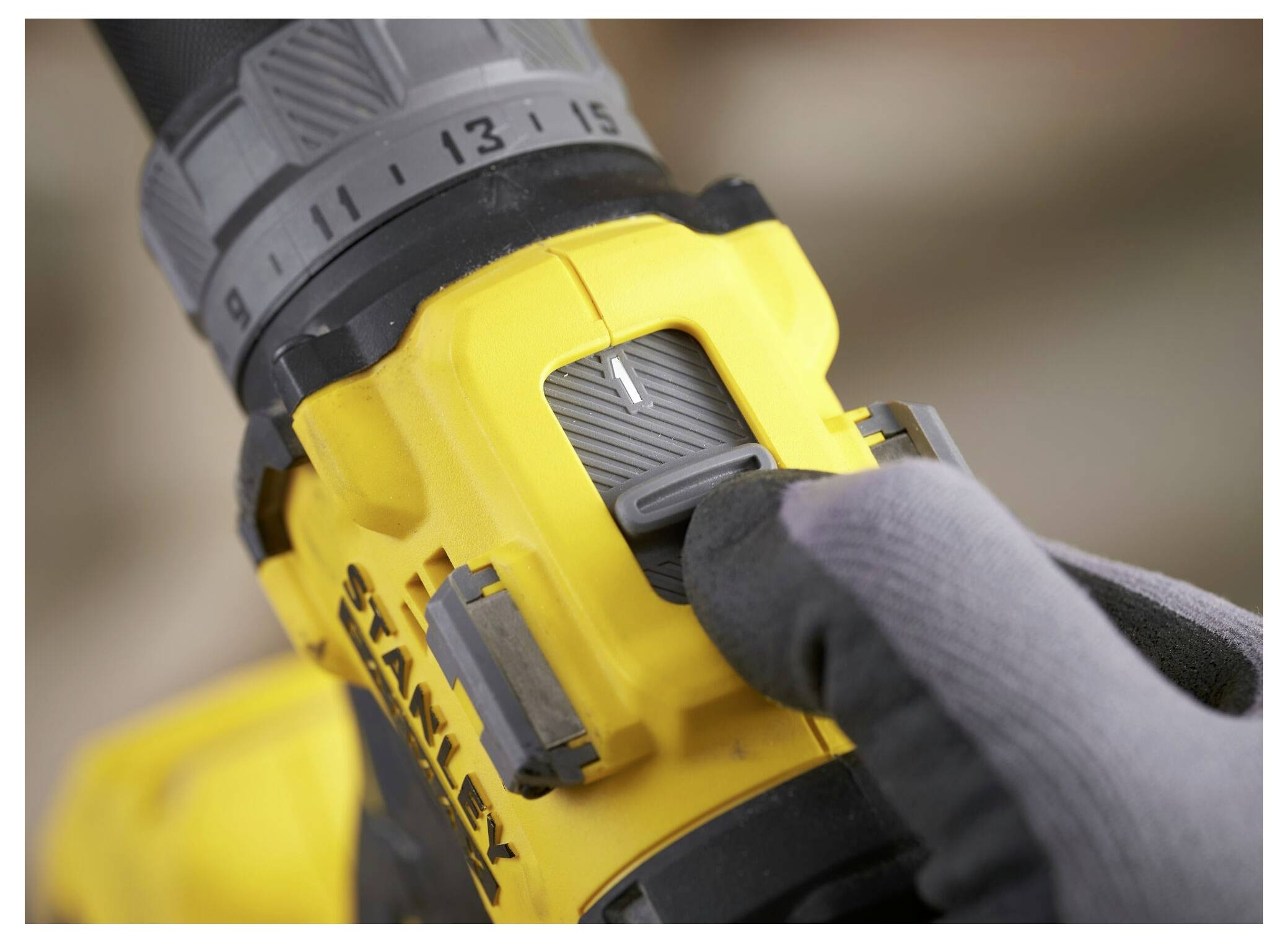 Eine Hand hält einen rot und gelb isolierten Schraubendreher mit dem sichtbaren Markennamen „Stanley