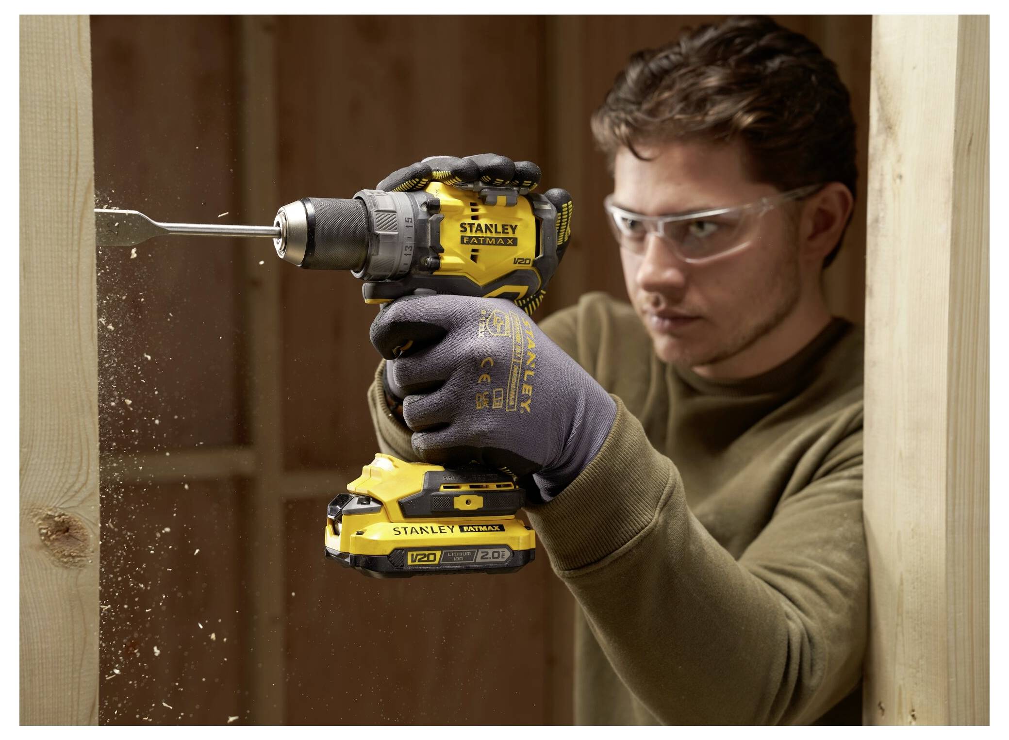 Eine Nahaufnahme einer Person, die die Ölkappe auf einer gelben Kettensäge verstellt, wobei Wartung oder Einsatzbereitschaft hervorgehoben wird.