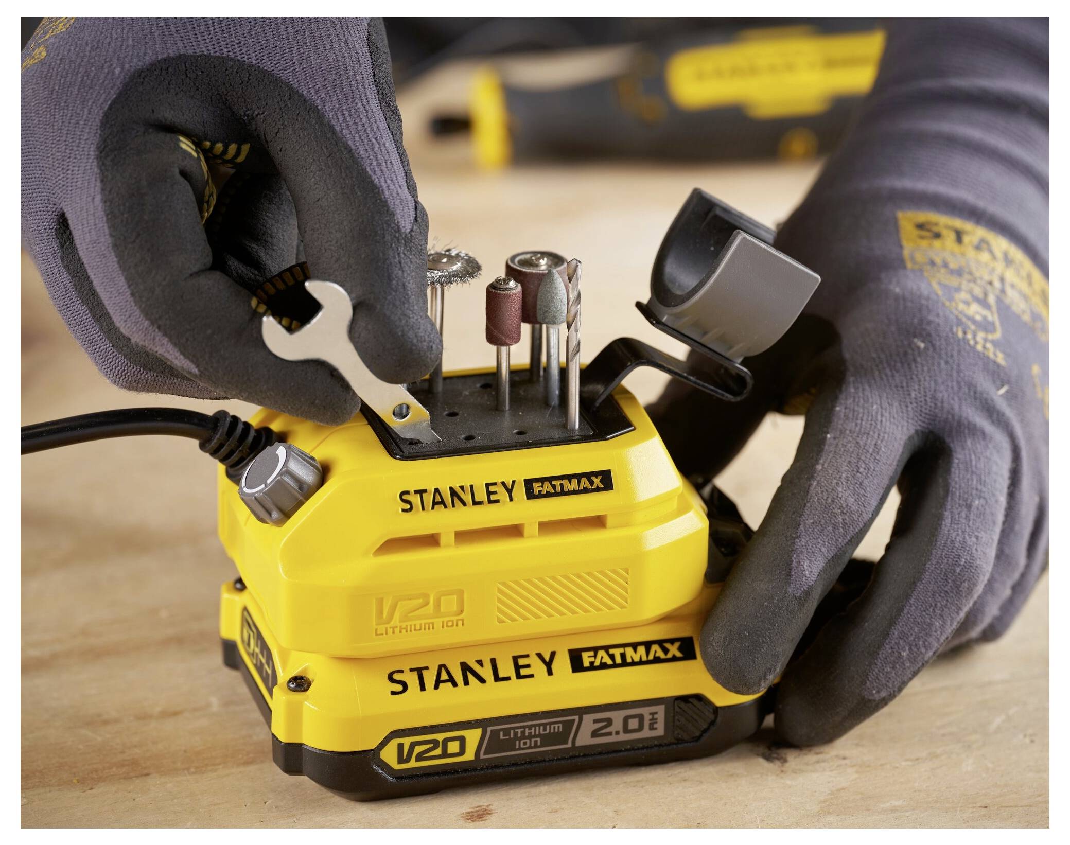 Hände, die einen kleinen Schraubenschlüssel an einem gelben 