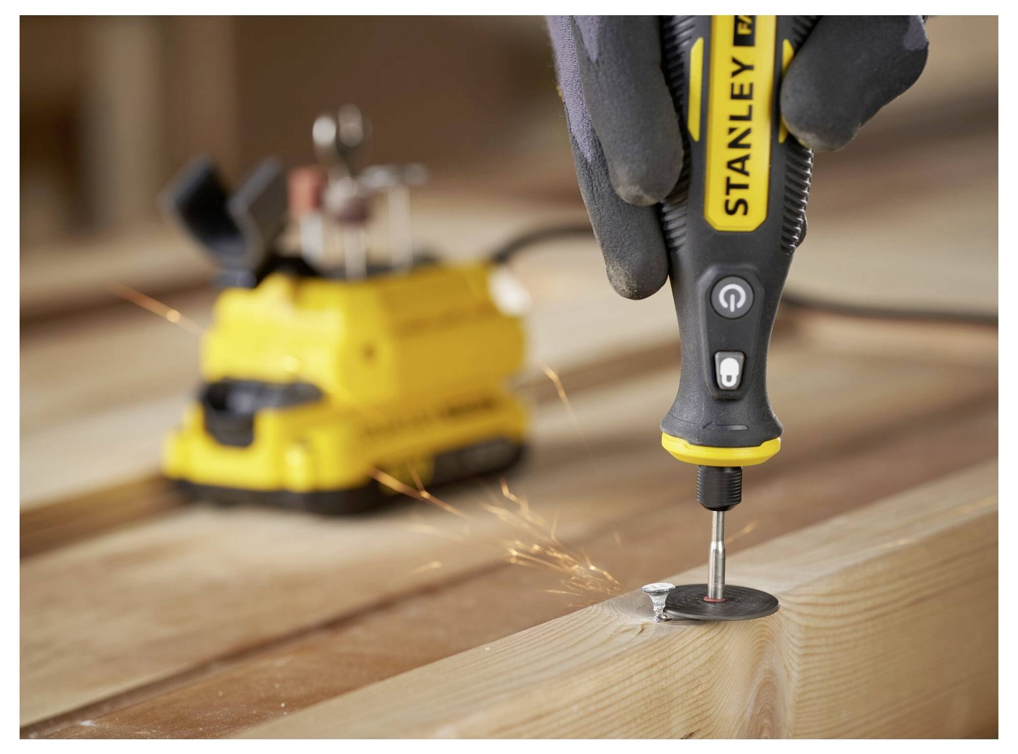 Eine Person benutzt einen Schneefräser, um Schnee an einem sonnigen Tag zu räumen, umgeben von schneebedeckten Bäumen und einer Steinstruktur.