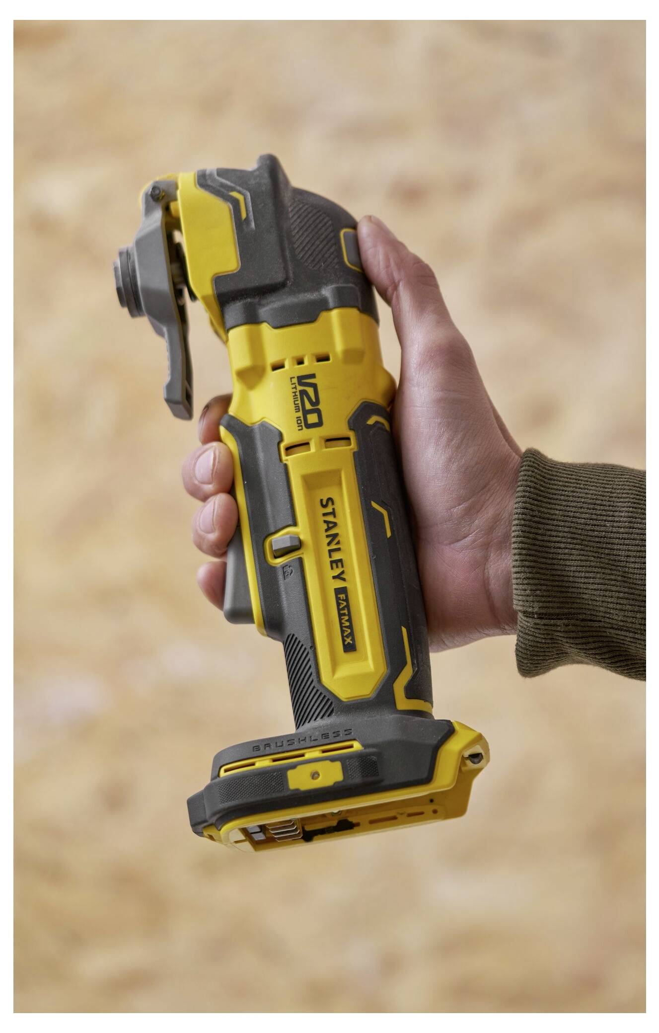 Eine Hand hält ein gelbes Stahllineal, das mehrere Zentimeter ausgefahren ist, und konzentriert sich auf eine genaue Messung gegen einen unscharfen Holzoberflächenhintergrund.