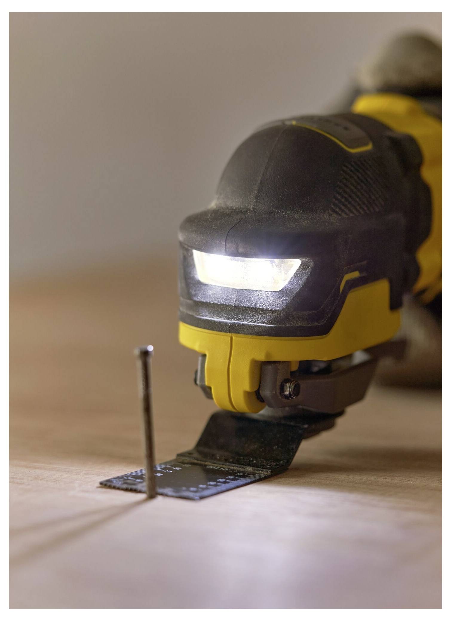 Eine Person verbindet ein Elektrowerkzeug mit einem Staubabsaugschlauch und zeigt damit sichere Holzbearbeitungspraktiken in einer Werkstattumgebung.