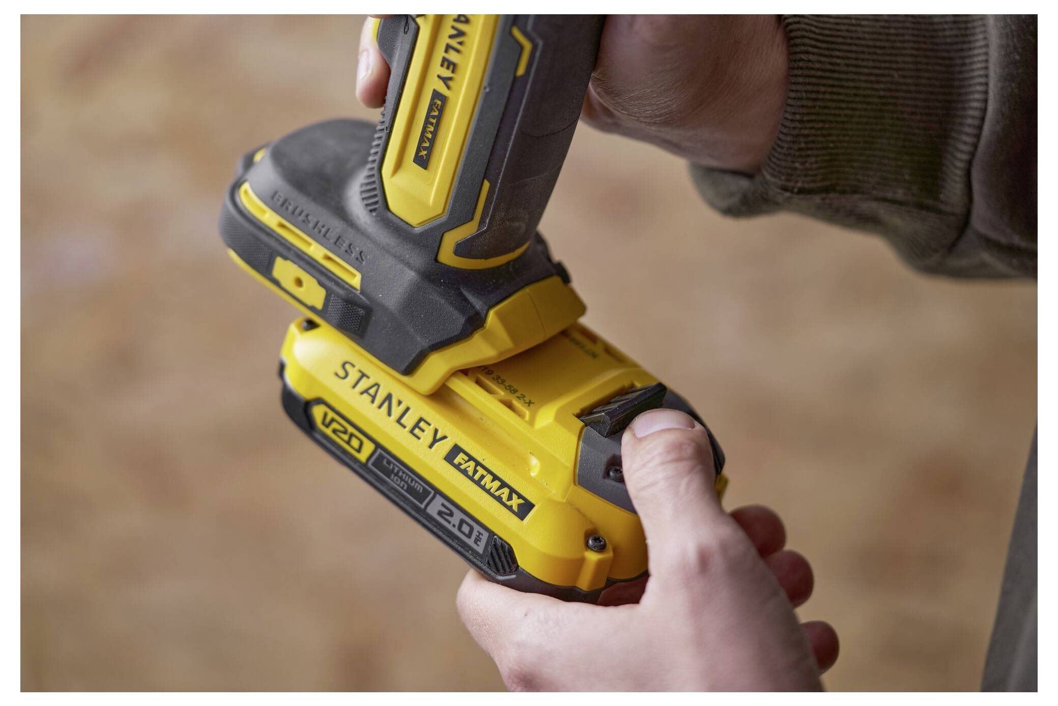 Eine Person befestigt eine gelbe „Stanley FATMAX V20 2.0Ah