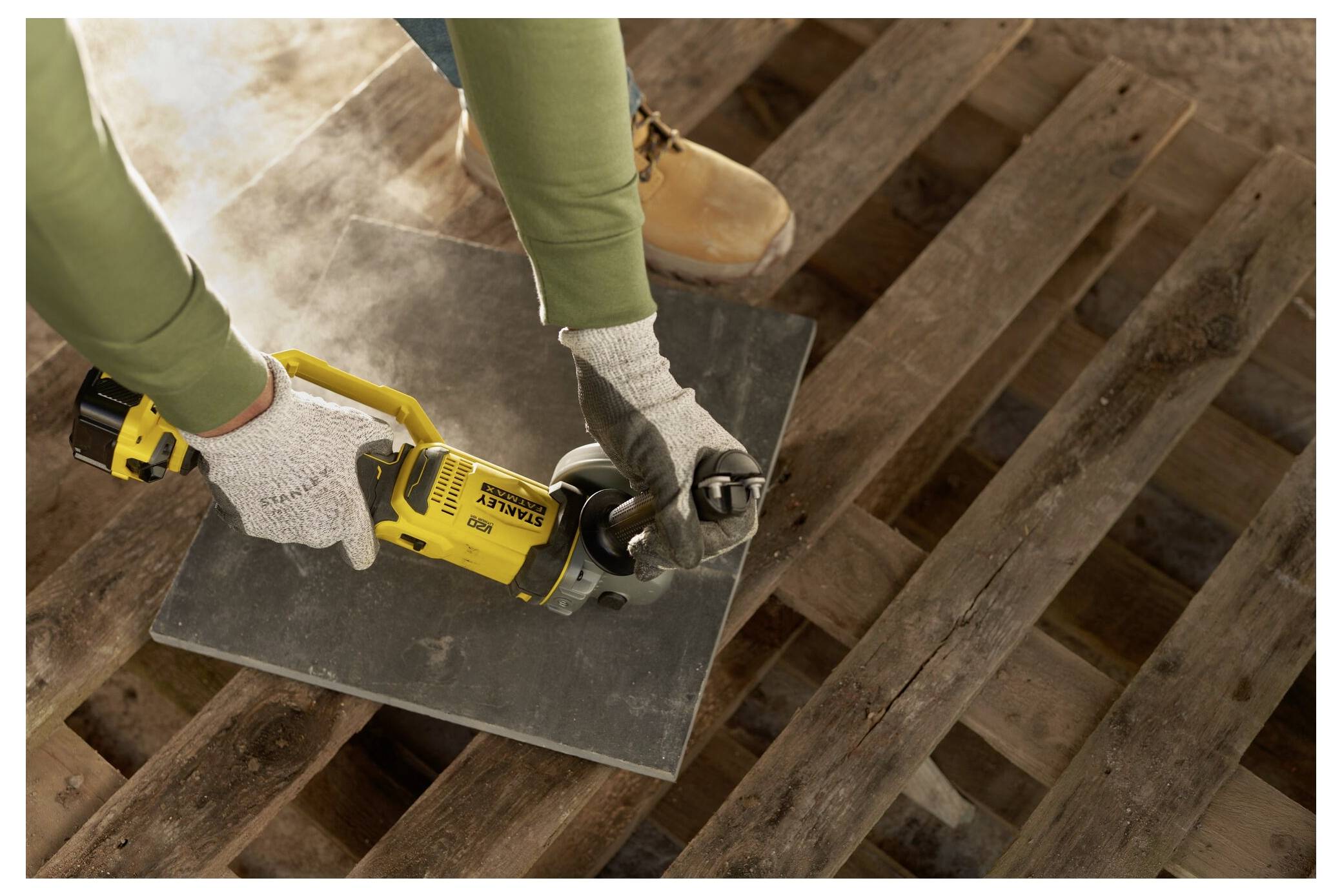 Ein gelber und schwarzer kabelloser Elektroschrauber mit einem spiralförmigen Augerbit, mit der Marke „Stanley Fatmax