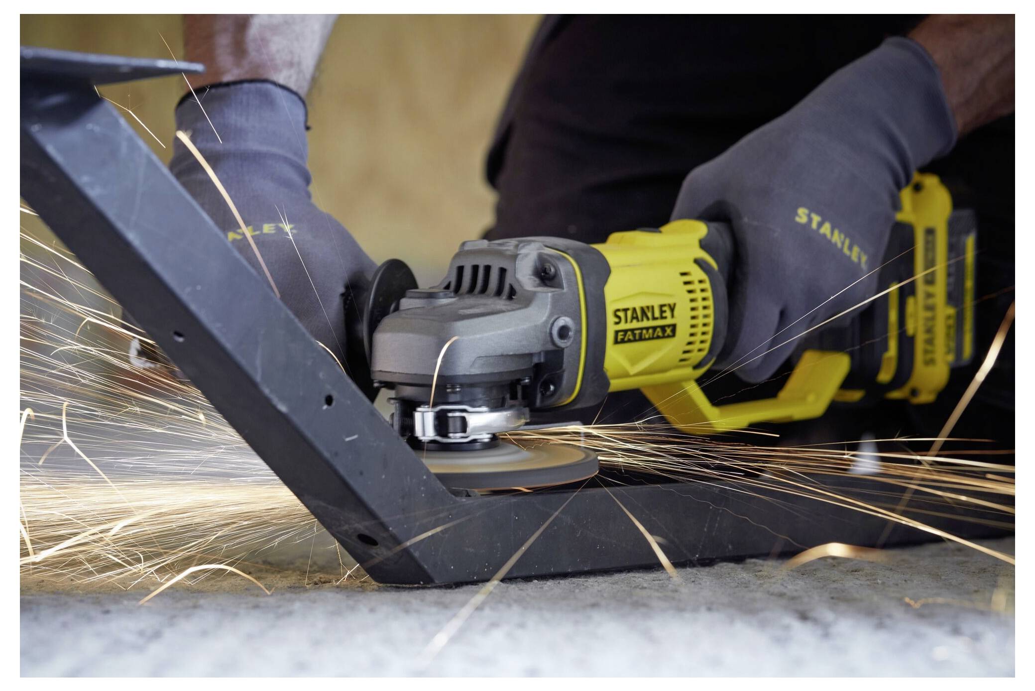 Eine Person benutzt einen elektrischen Winkelschleifen zum Schneiden von Metall, wobei Funken fliegen. Das Werkzeug wird sicher in behandschuhten Händen gehalten, konzentriert auf die Aufgabe.